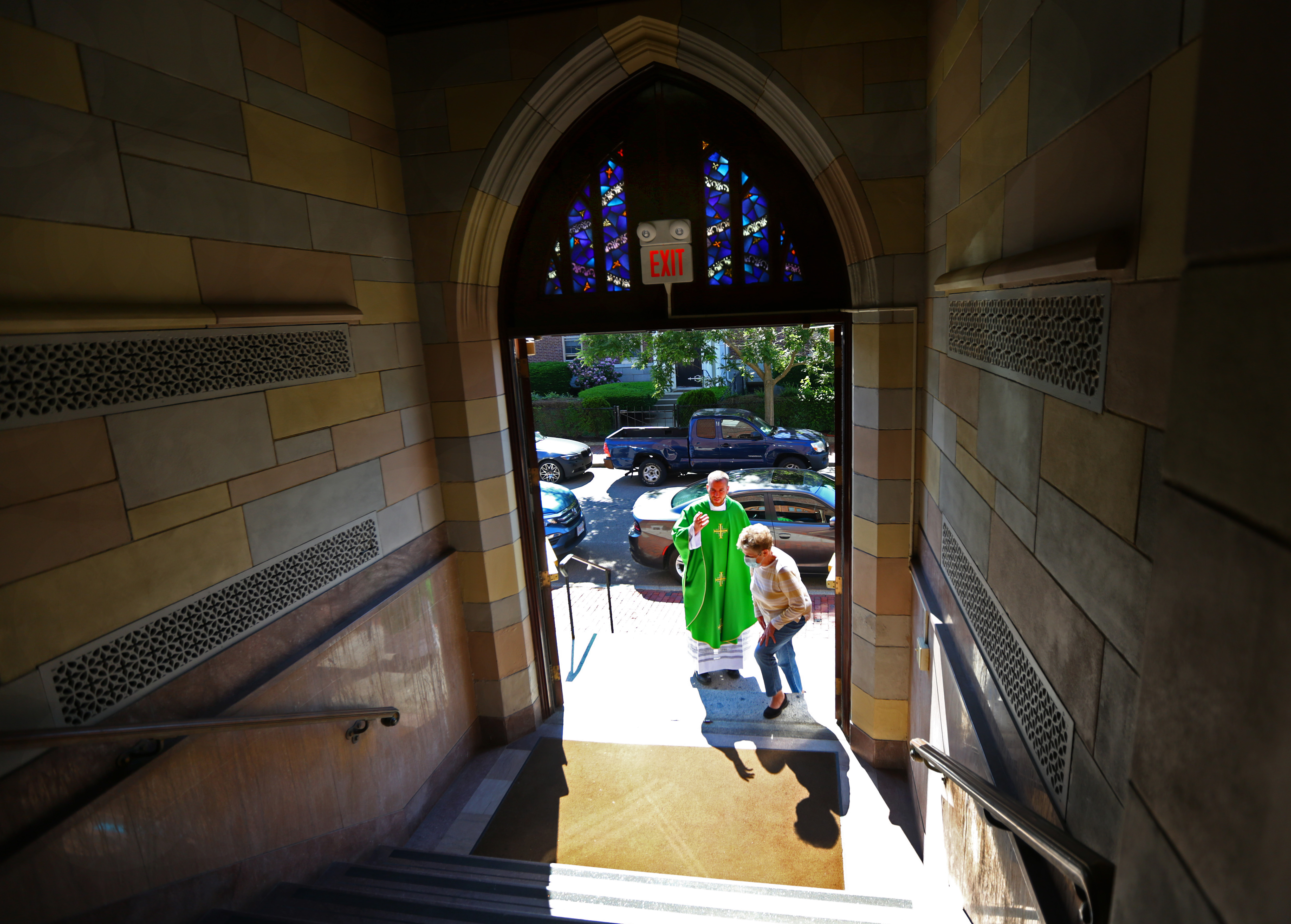 The Rev. Daniel Zinger welcomed a woman to Mass at St. Mary of the Annunciation Parish in Cambridge.