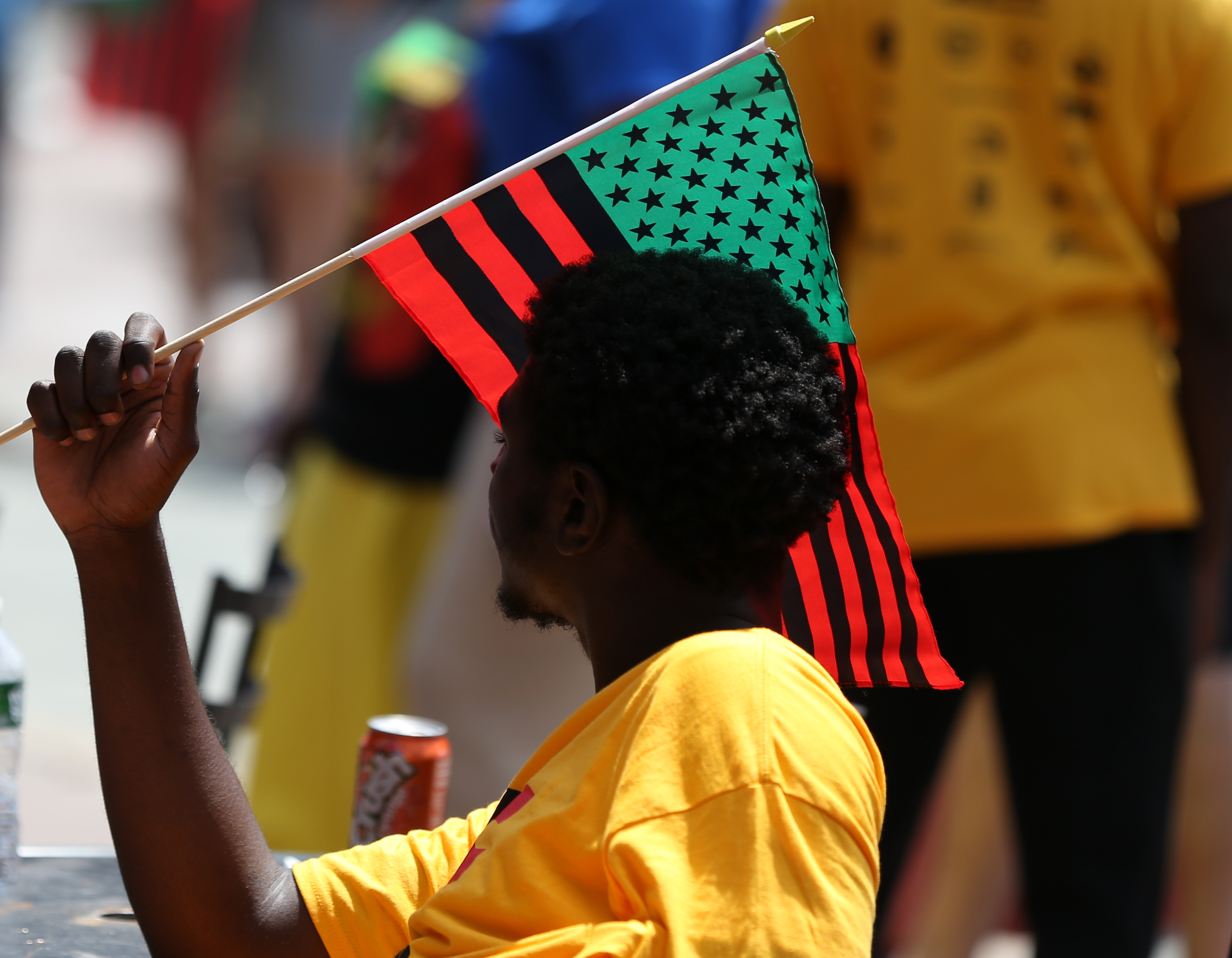 Alhoussene Kaba waved a flag at the Juneteenth celebration at Copley Square in Boston.