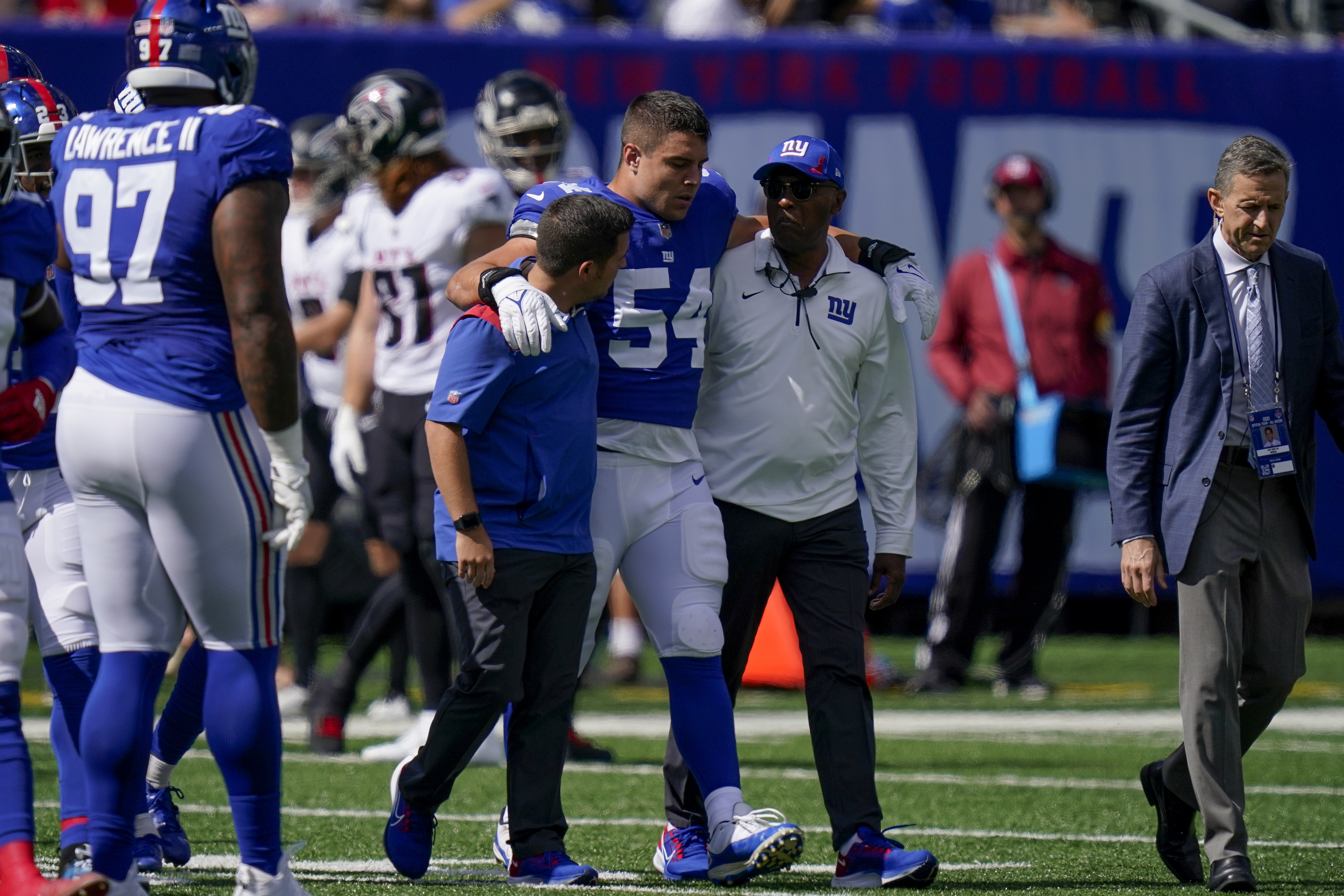 Blake Martinez is walked off the field after suffering a season-ending injury Sunday against the Falcons.