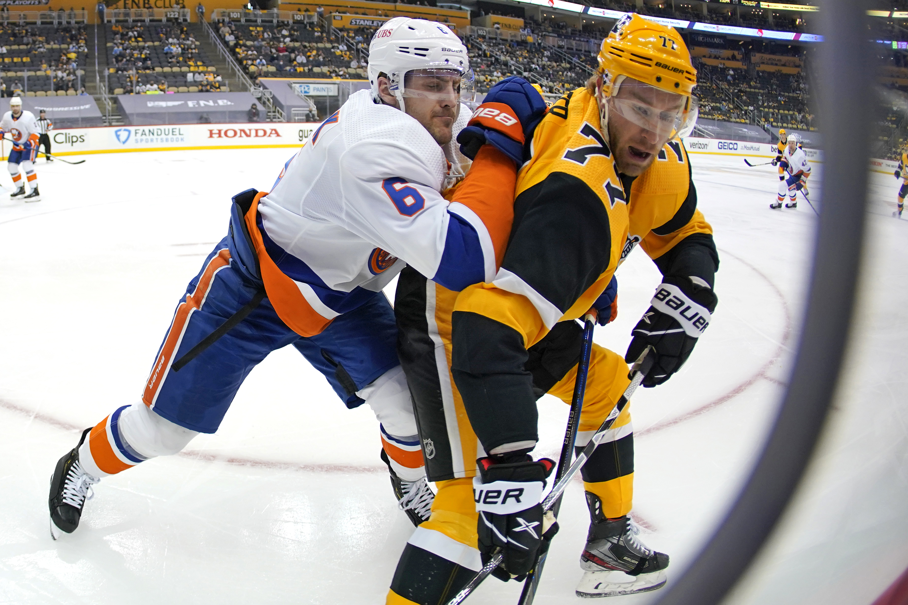 Pittsburgh's Jeff Carter goes into the corner for the puck with New York's Ryan Pulock defending during the second period of Sunday's contest.