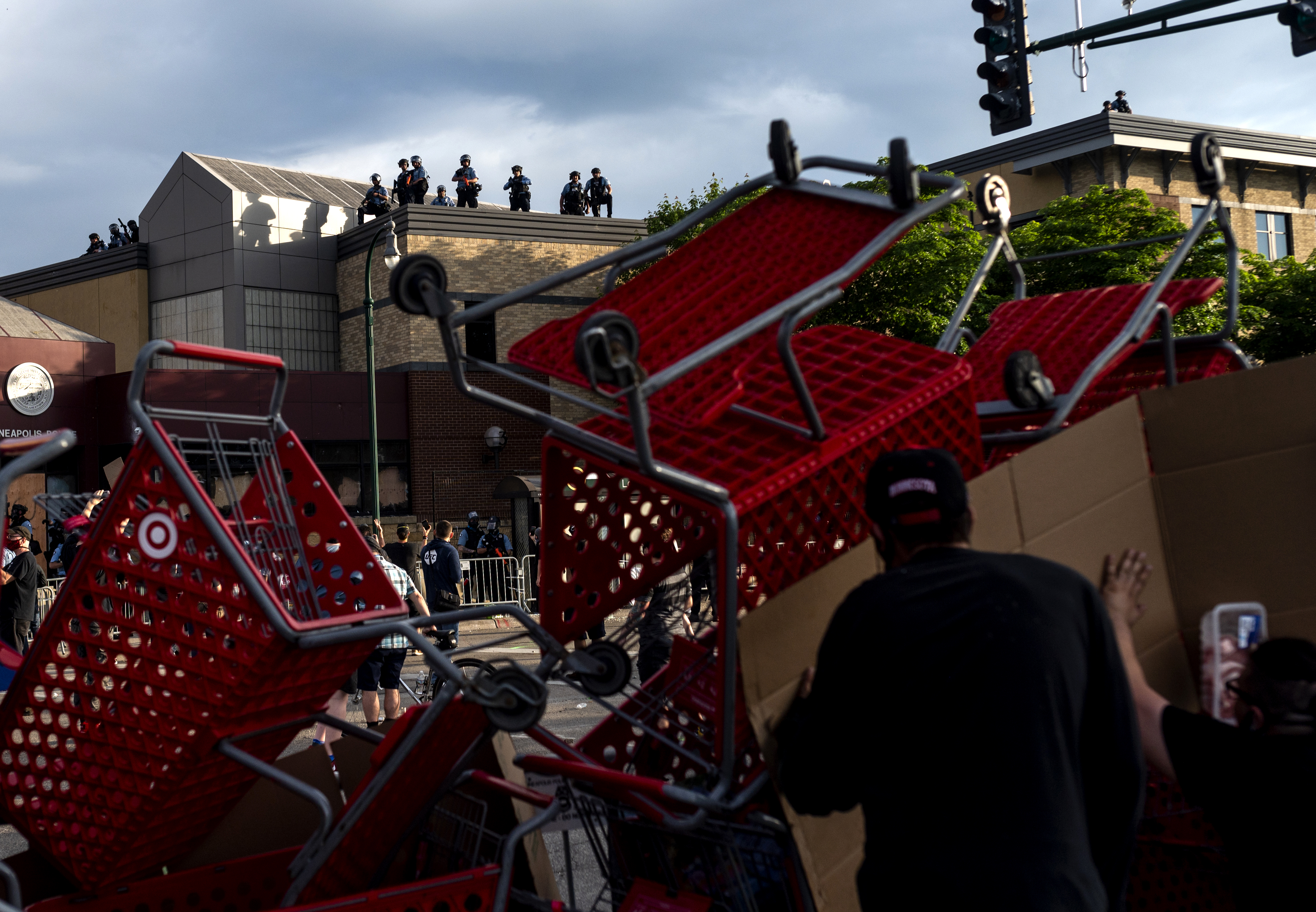 Protesters used shopping carts as a barricade as they confront police near the Third Police Precinct.