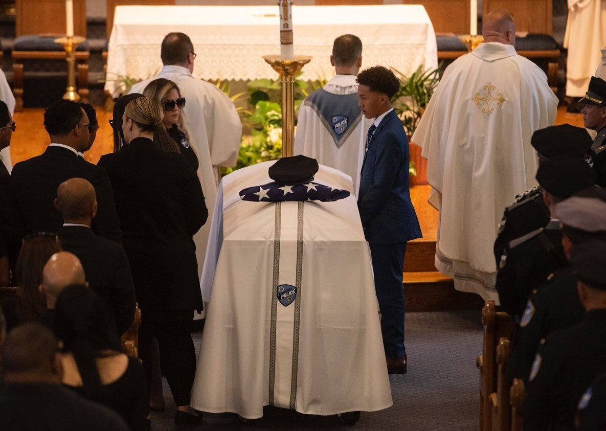 Family members cover the casket of Worcester police Officer Enmanuel “Manny” Familia during a funeral Mass at St. John's Catholic Church.