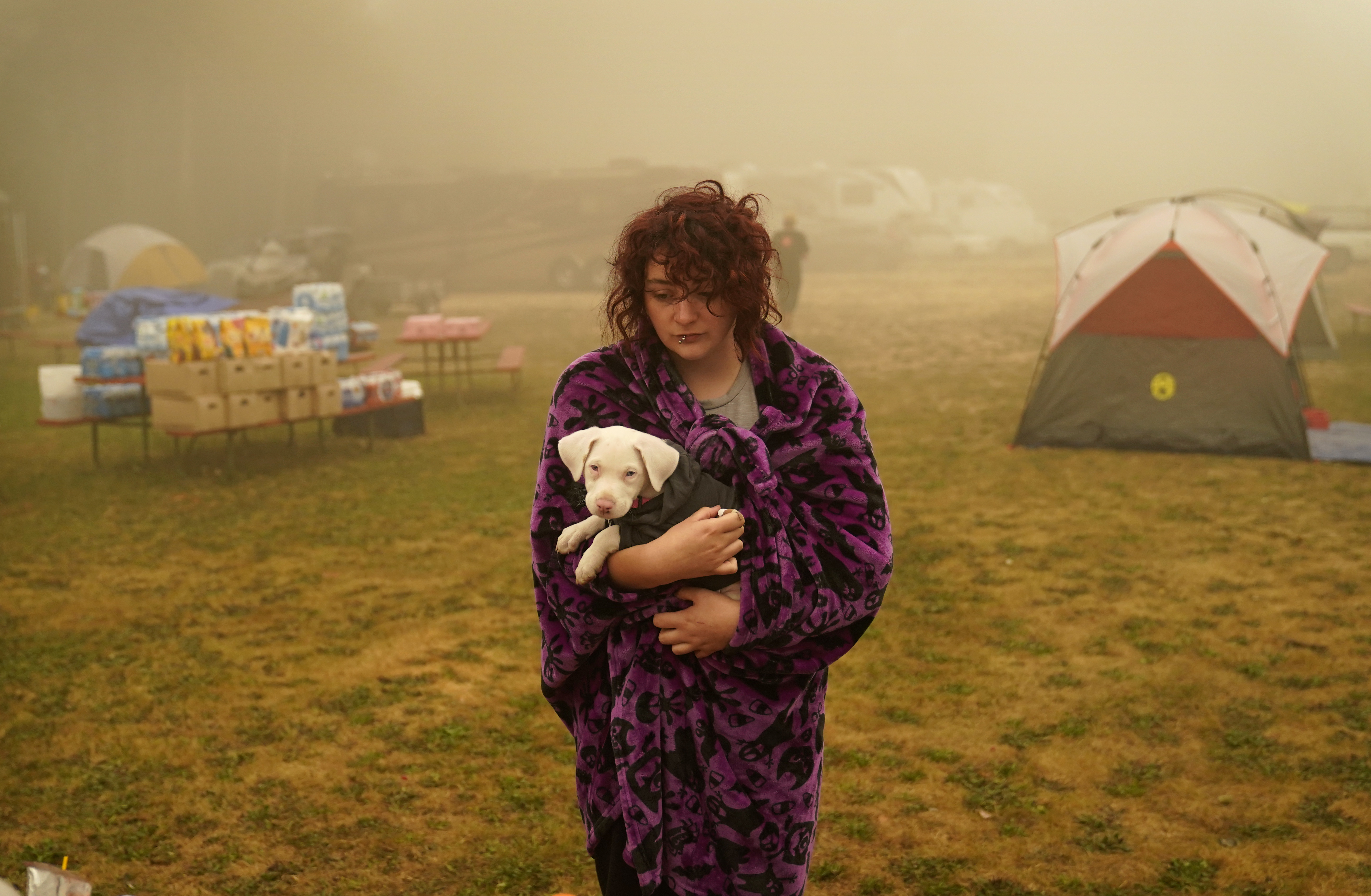 Shayanne Summers held her dog Toph while wrapped in a blanket after several days of staying in a tent at an evacuation center at the Milwaukie-Portland Elks Lodge in Oak Grove, Ore.