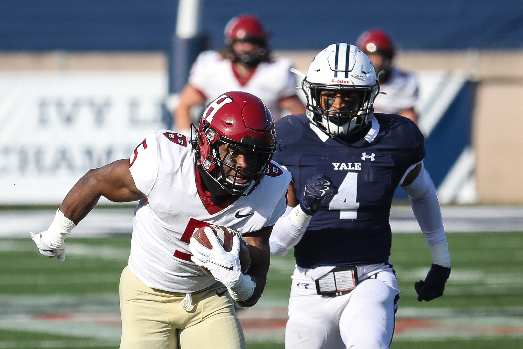 Harvard senior B.J. Watson (left) runs with the ball after making a catch during the second quarter against Yale.