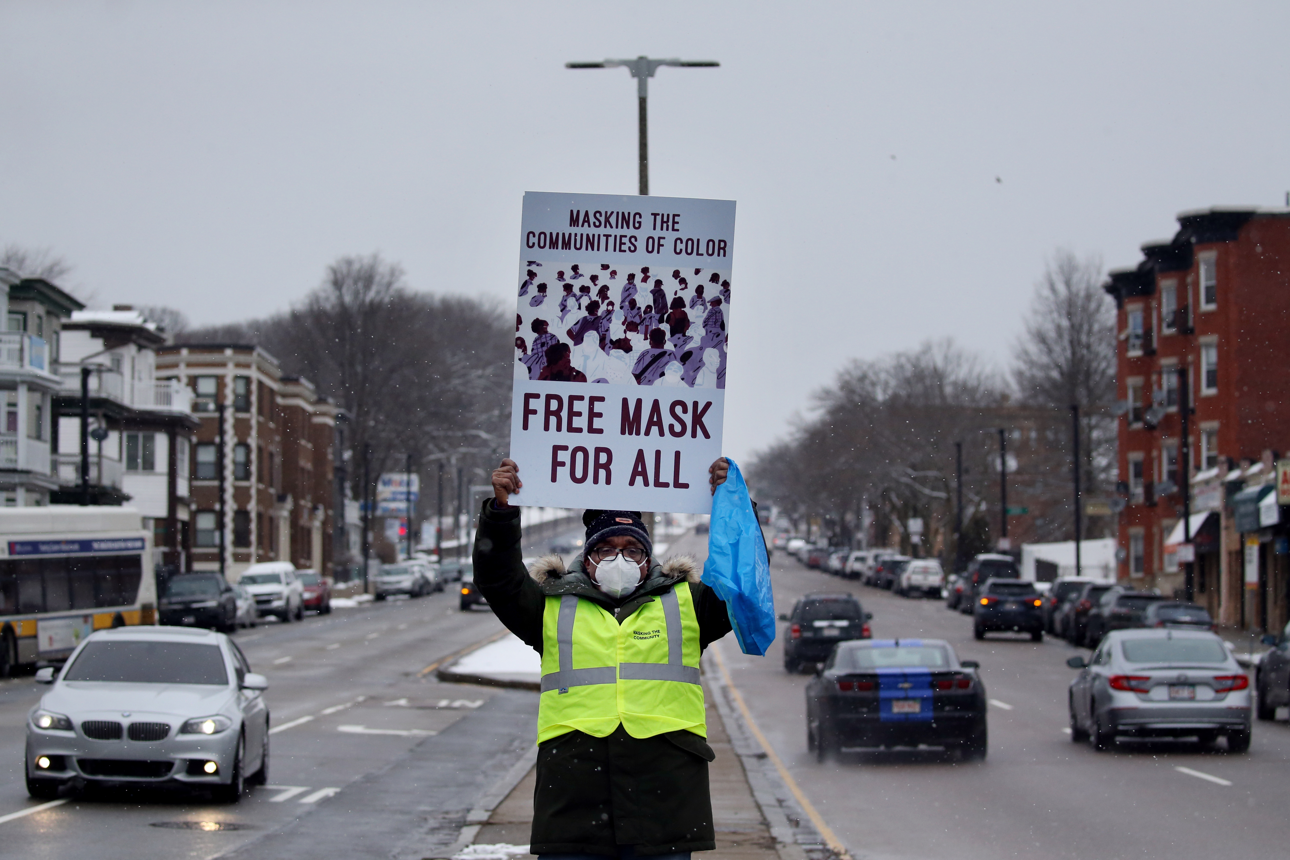 Leonard Lee offers free masks and hand sanitizer to drivers and pedestrians at the intersection of Talbot Avenue and Blue Hill Avenue in Dorchester in January.