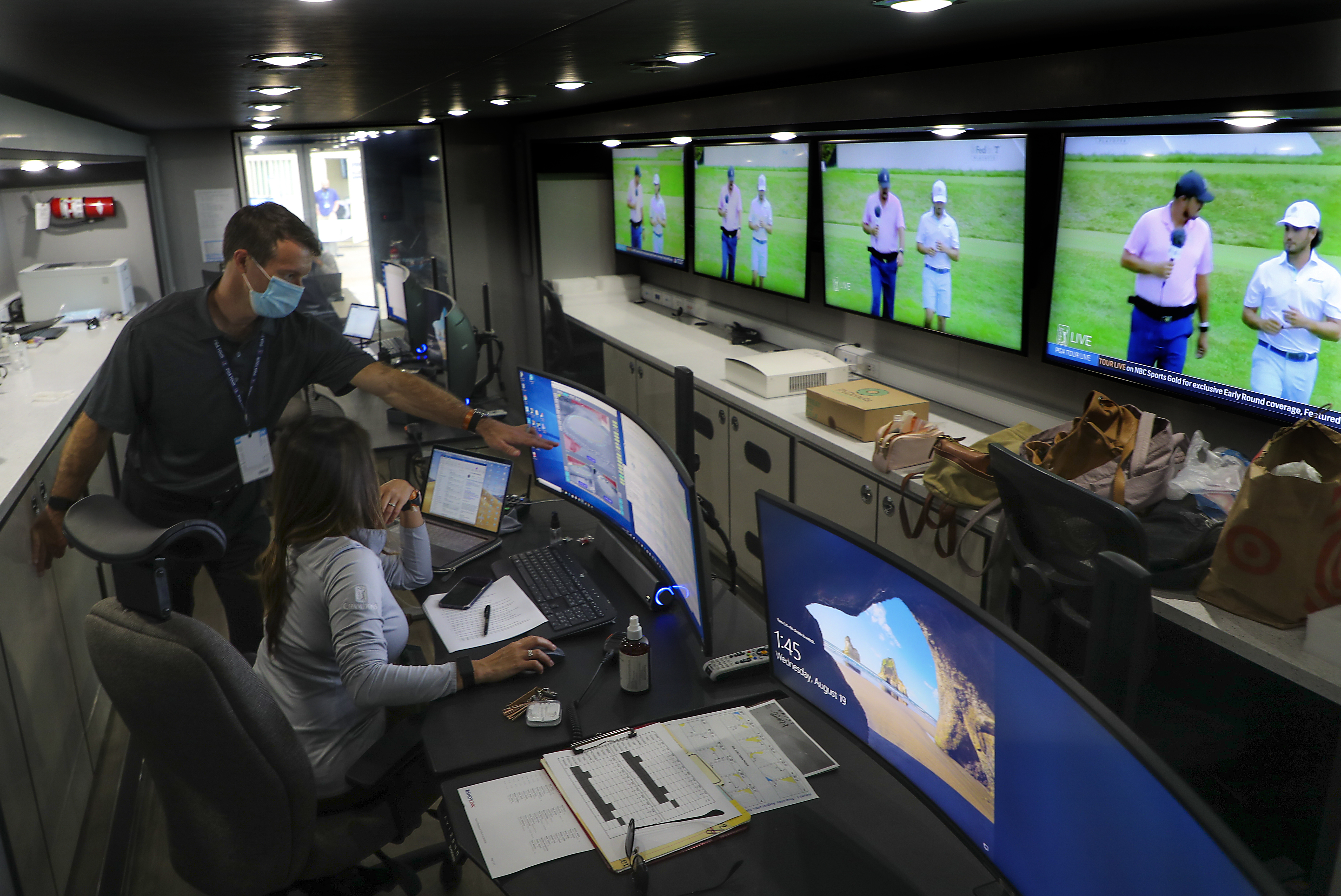 Managing producer Zac Doyle and senior producer Mary Nguyen confer in the ShotLink control room trailer during the Northern Trust Charity Challenge.