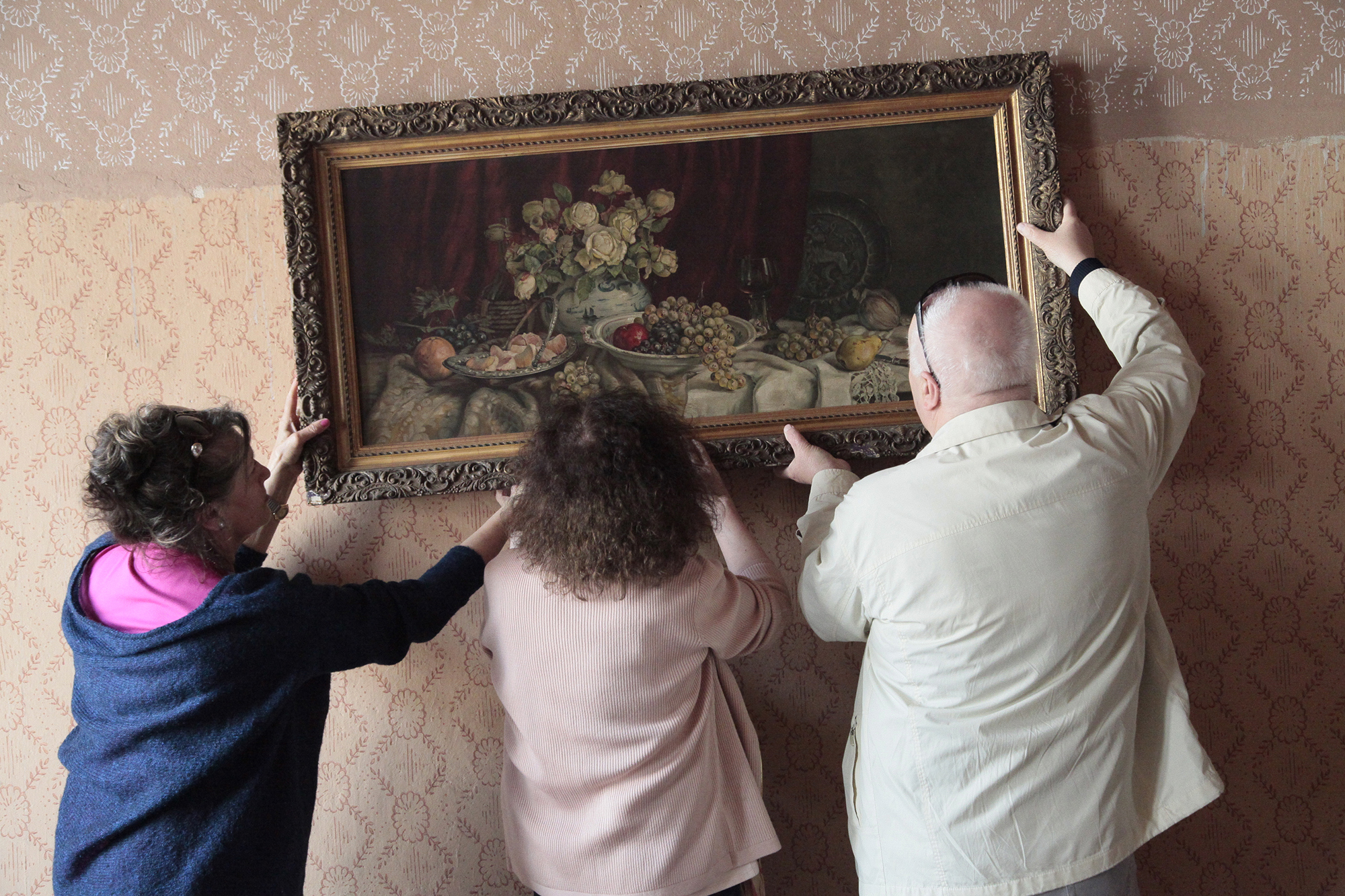 New and old owners hang up the still-life painting that's at the heart of
"Still Life in Lodz."
