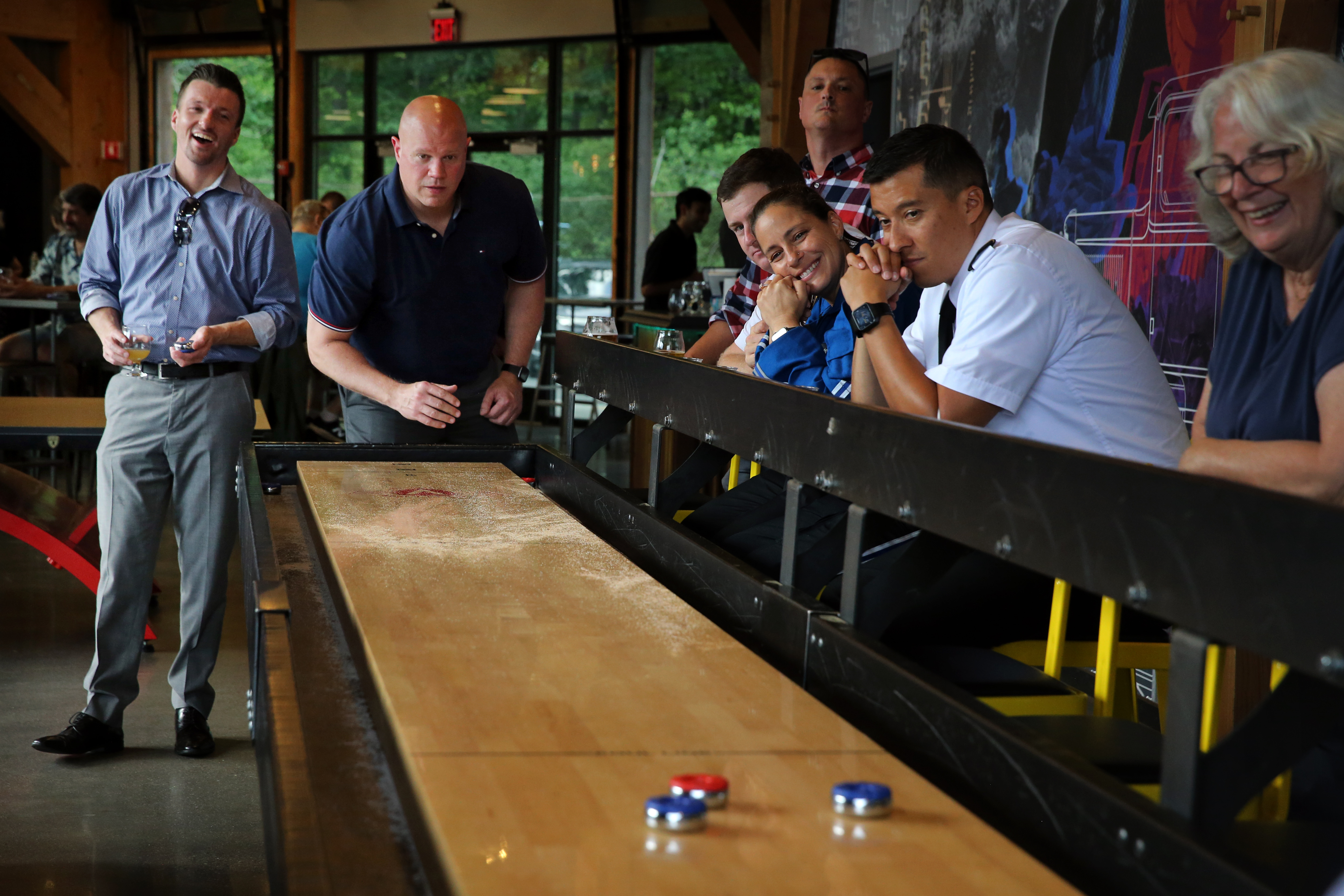 Dan O'Connell (left) and Brian Gourley play shuffleboard at Revolution Hall, a new food hall and entertainment area in Lexington.