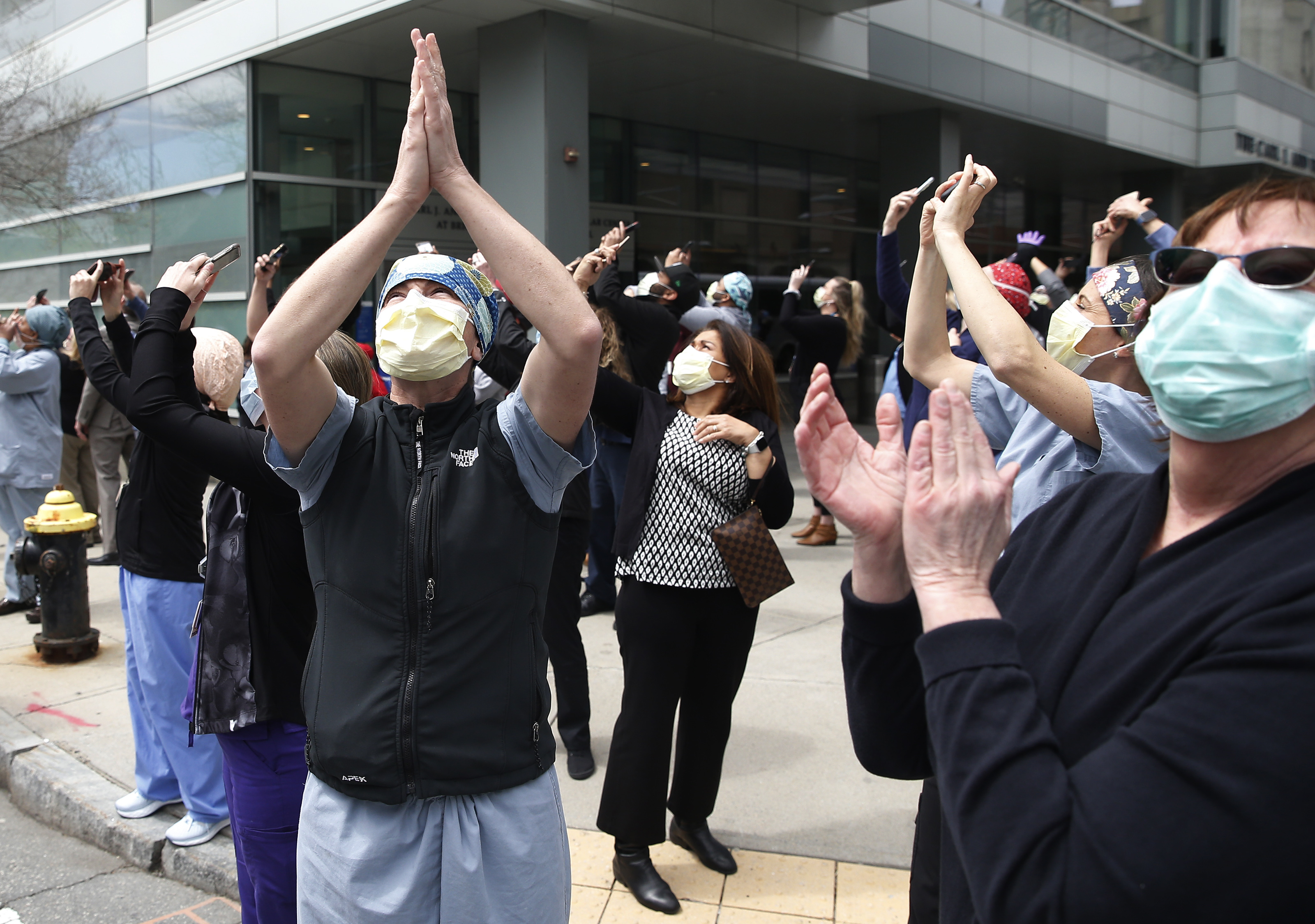 Boston, MA - 5/6/20: Nurses, doctors and medical workers stood outside of Brigham and Women's cheering and taking pictures as the Massachusetts National Guard 104th Fighter Wing did a flyover as a show of support during COVID-19 pandemic. (Jessica Rinaldi/Globe Staff)