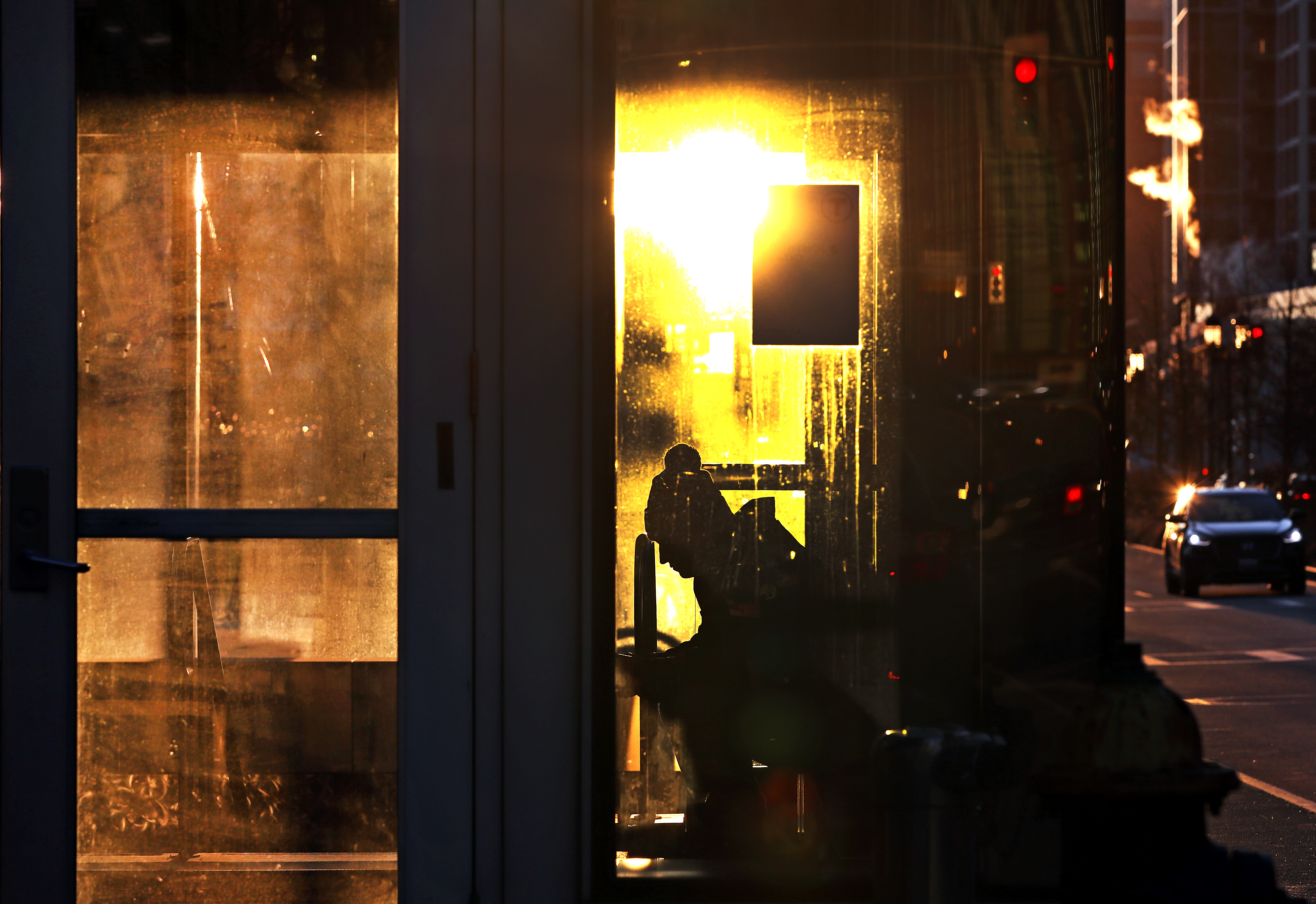 Waiting for his ride, a commuter kept warm inside the MBTA Silverline street level exit in the Seaport District on the morning of January 17.