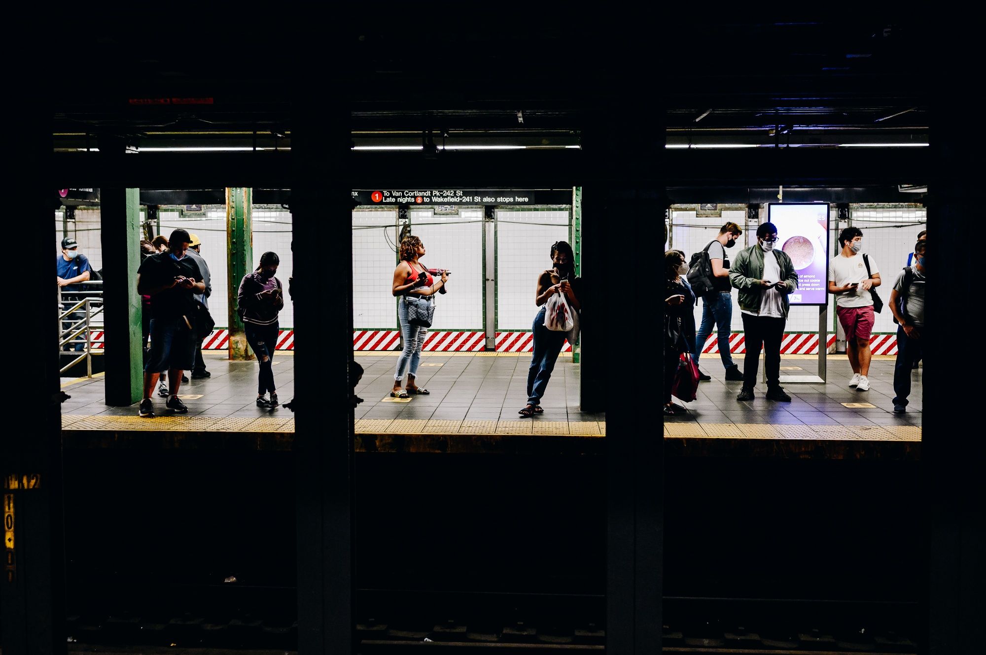 Subway riders wait on the platform at Times Square in New York, on Monday, June 14, 2021.