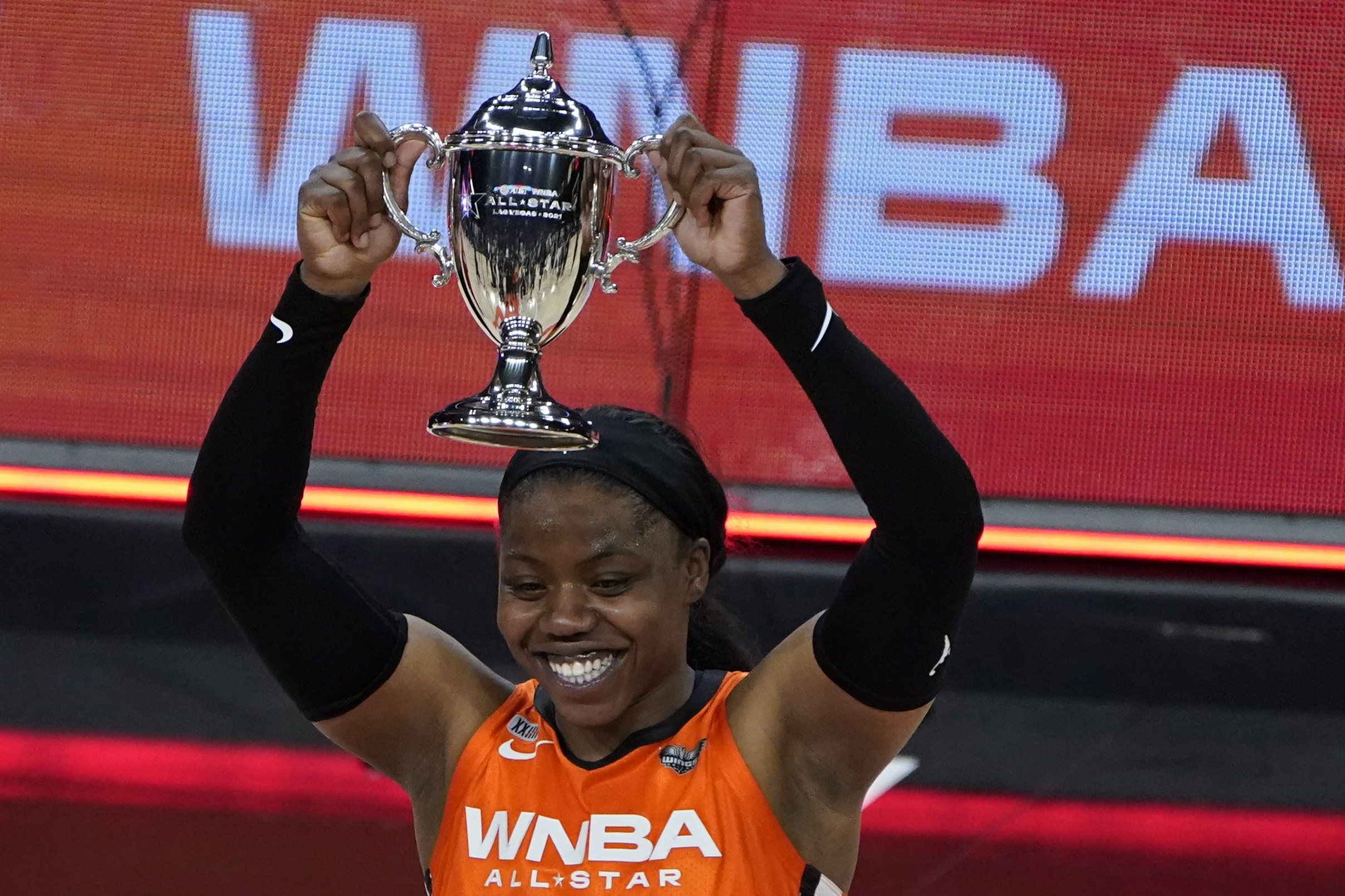 Arike Ogunbowale of Team WNBA holds up the MVP trophy after the