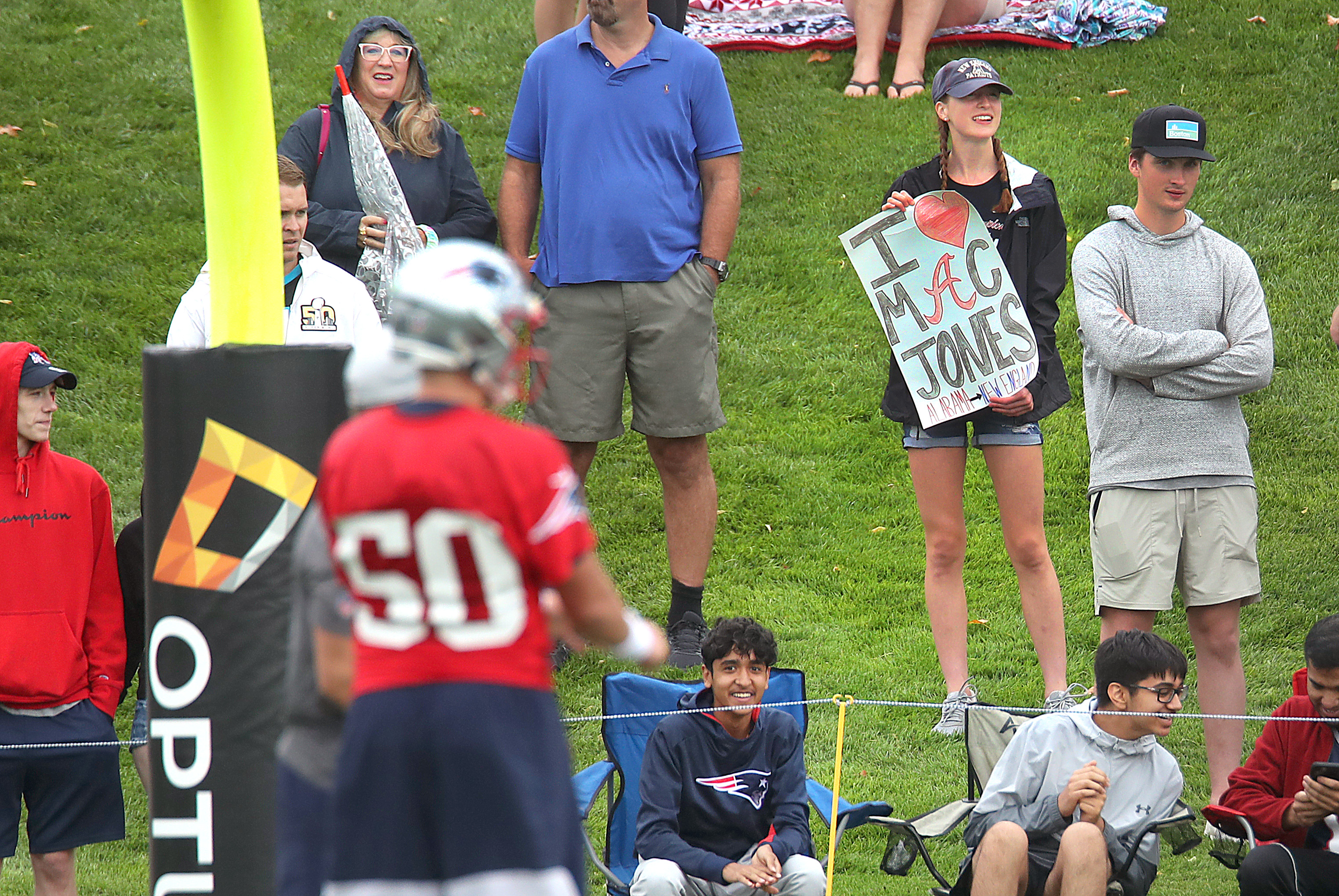 A fan held a sign as Mac Jones got set to throw a pass.