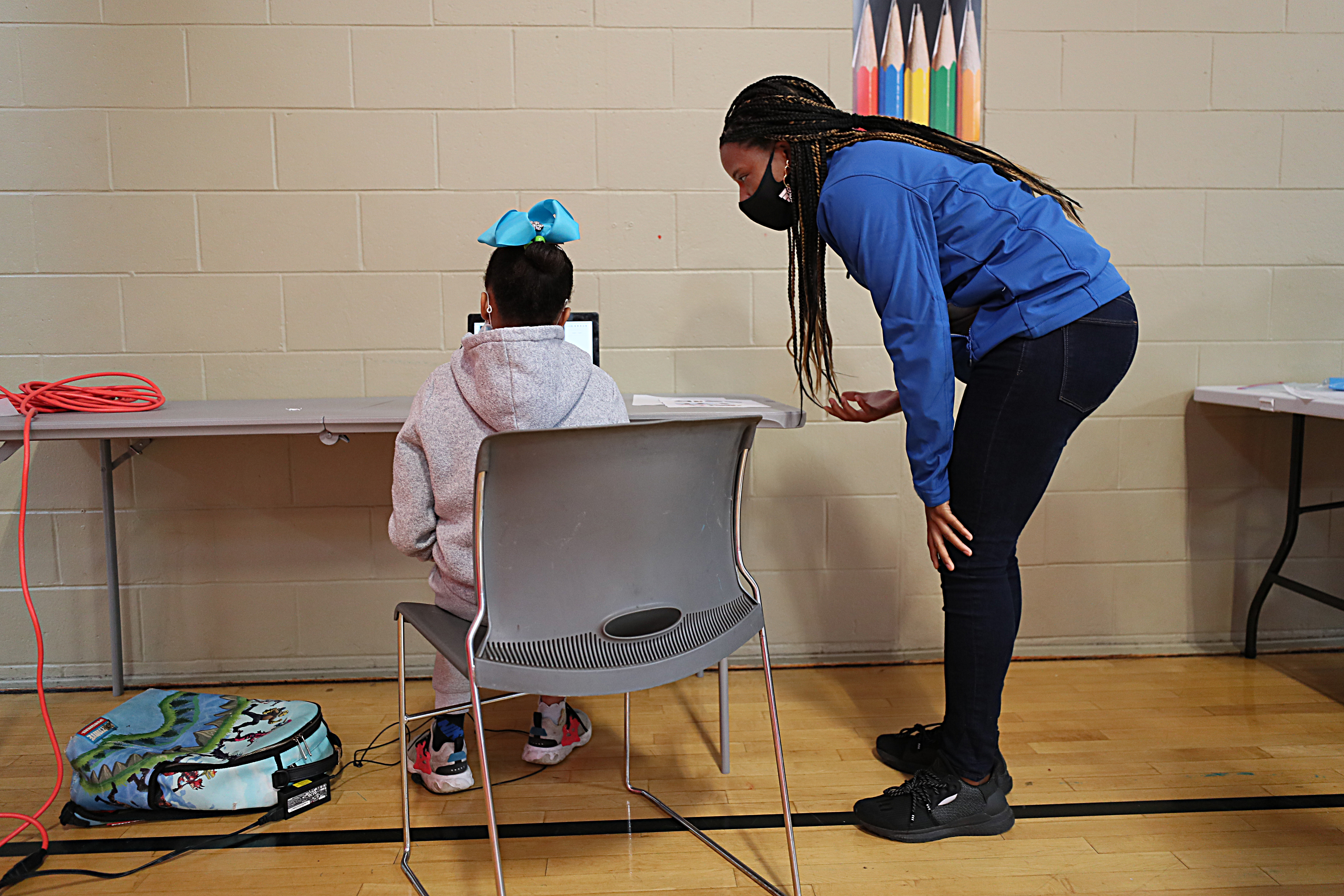 After-school Site Coordinator Giselle Johnson helped a student who was having a tough moment during her remote school learning at the Roxbury YMCA on Monday.