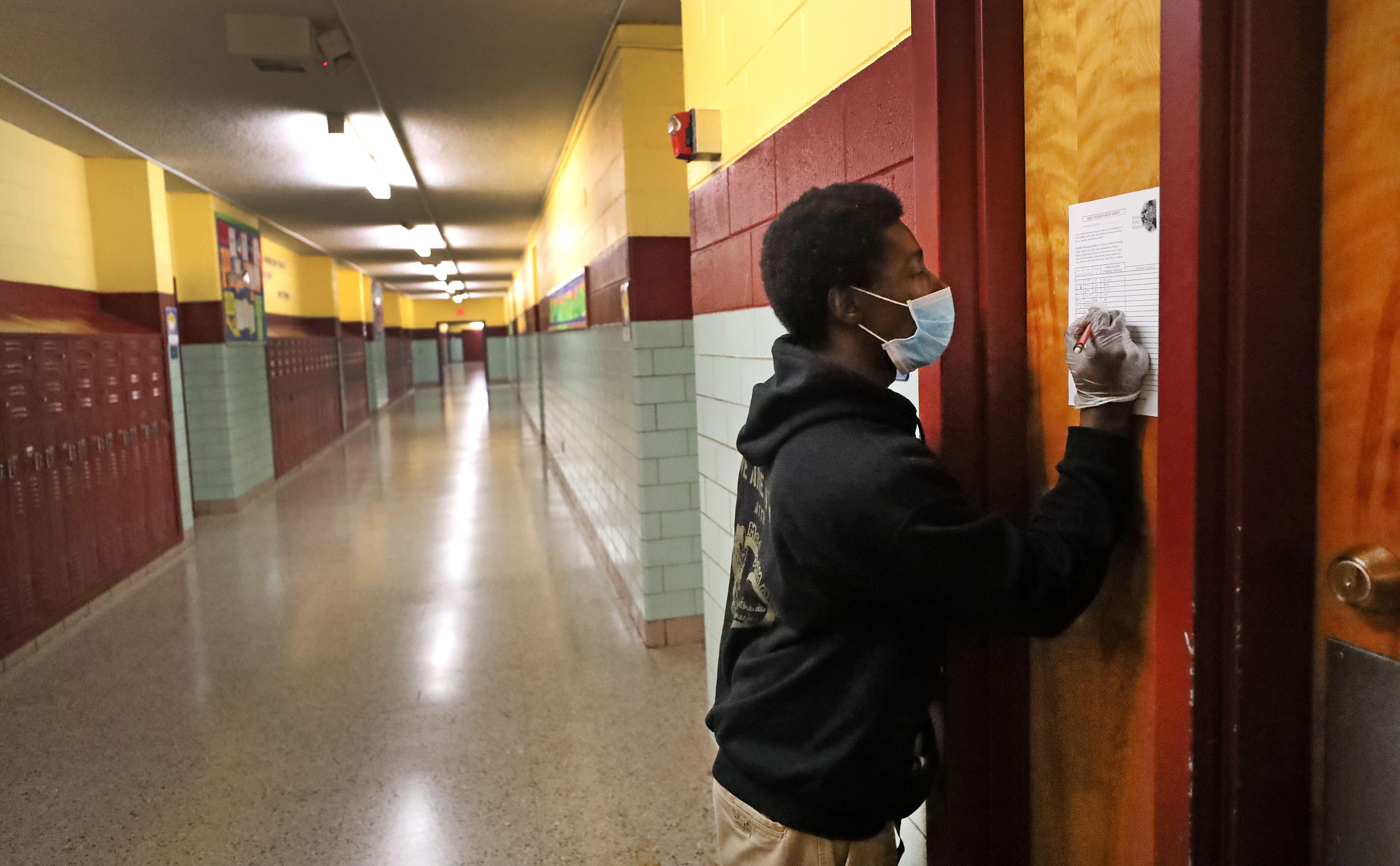 Earnest Bass wrote on a log sheet for rooms that have been cleaned and sanitized.