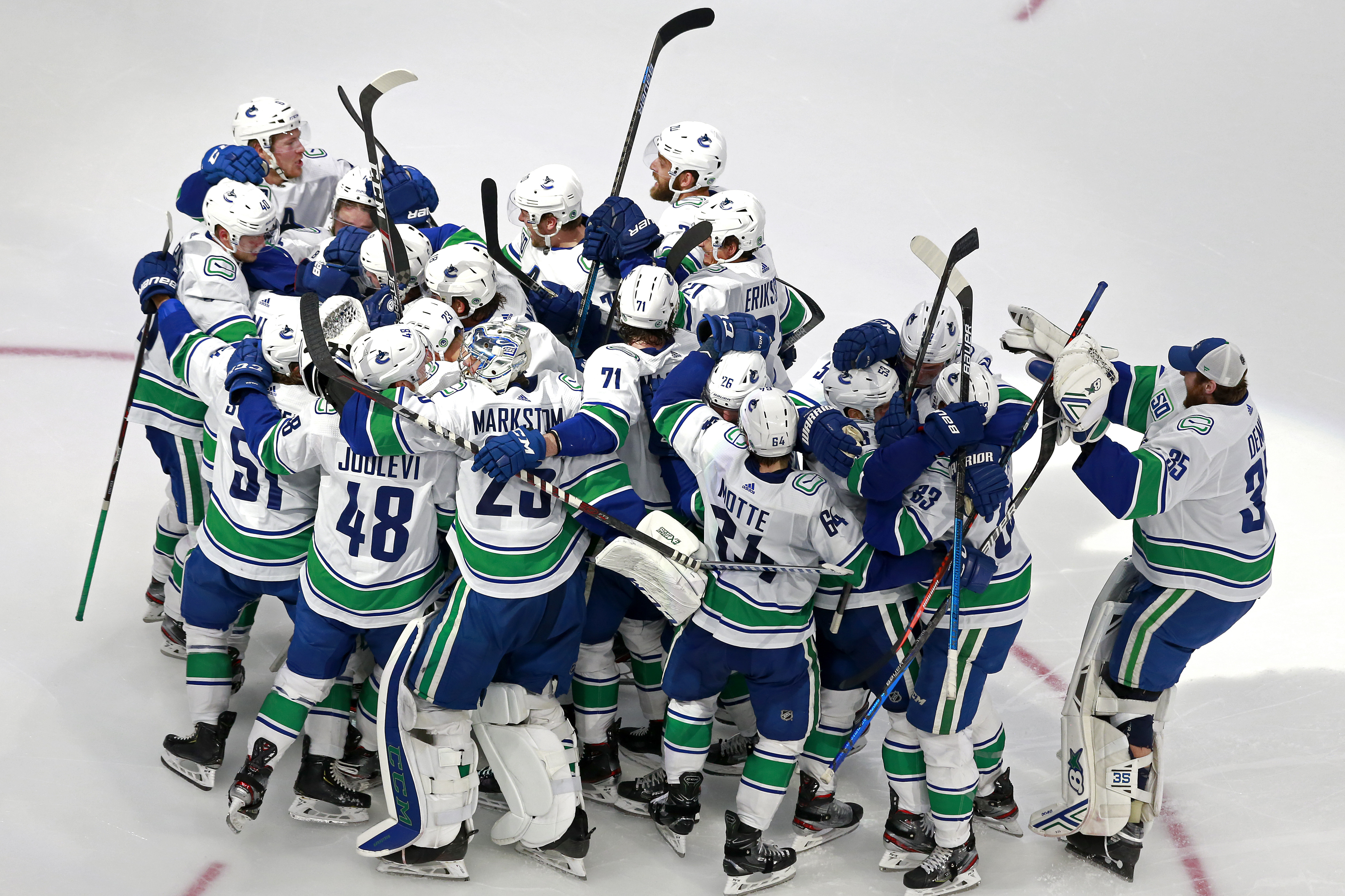 Vancouver Canucks players celebrate after their 5-4 overtime victory over the Minnesota Wild on Friday in Edmonton, wrapping up the best-of-five qualifier series in four games.