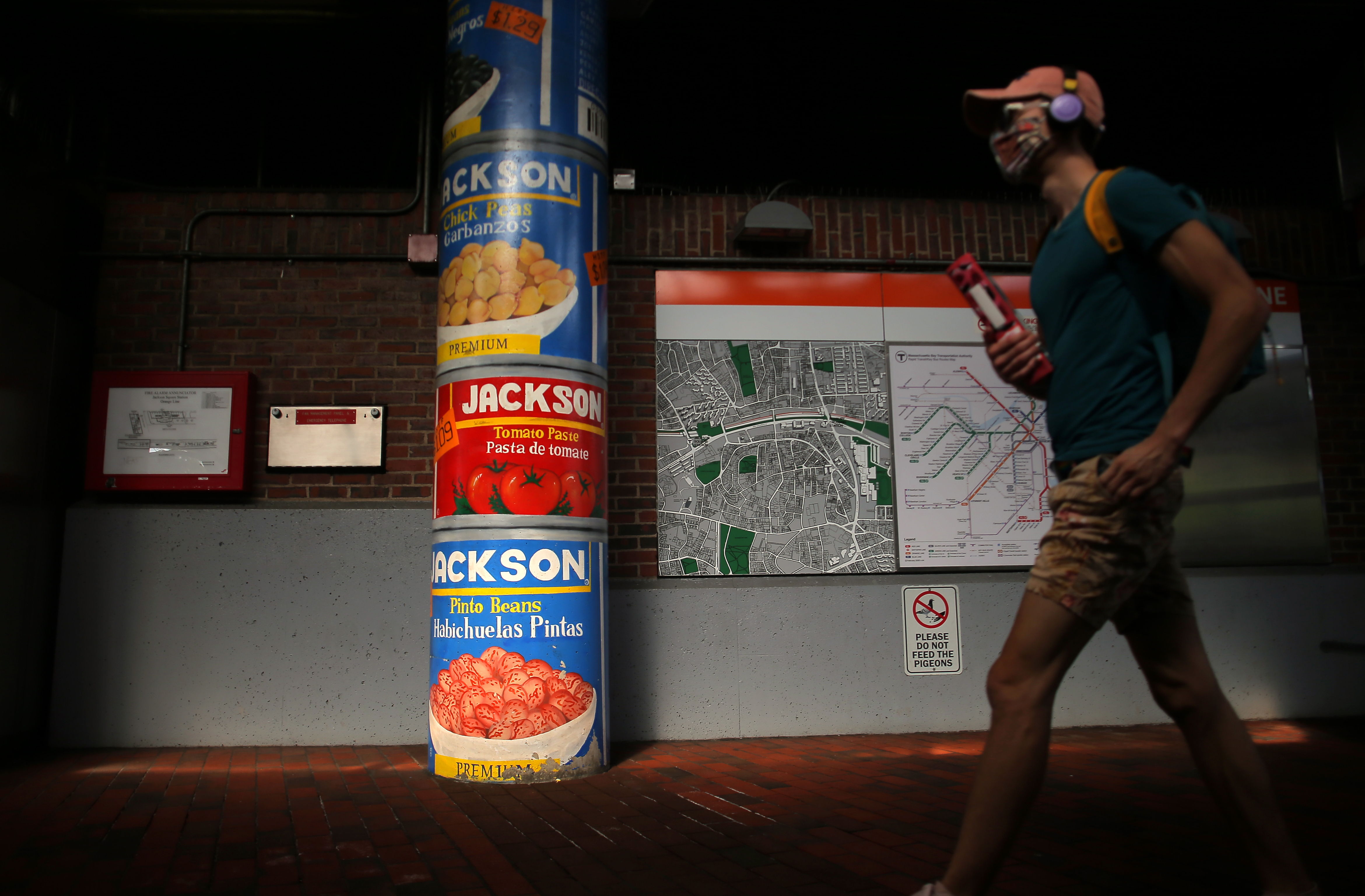 A passenger passes a column painted to resemble stacked food cans at the Jackson Square station.
