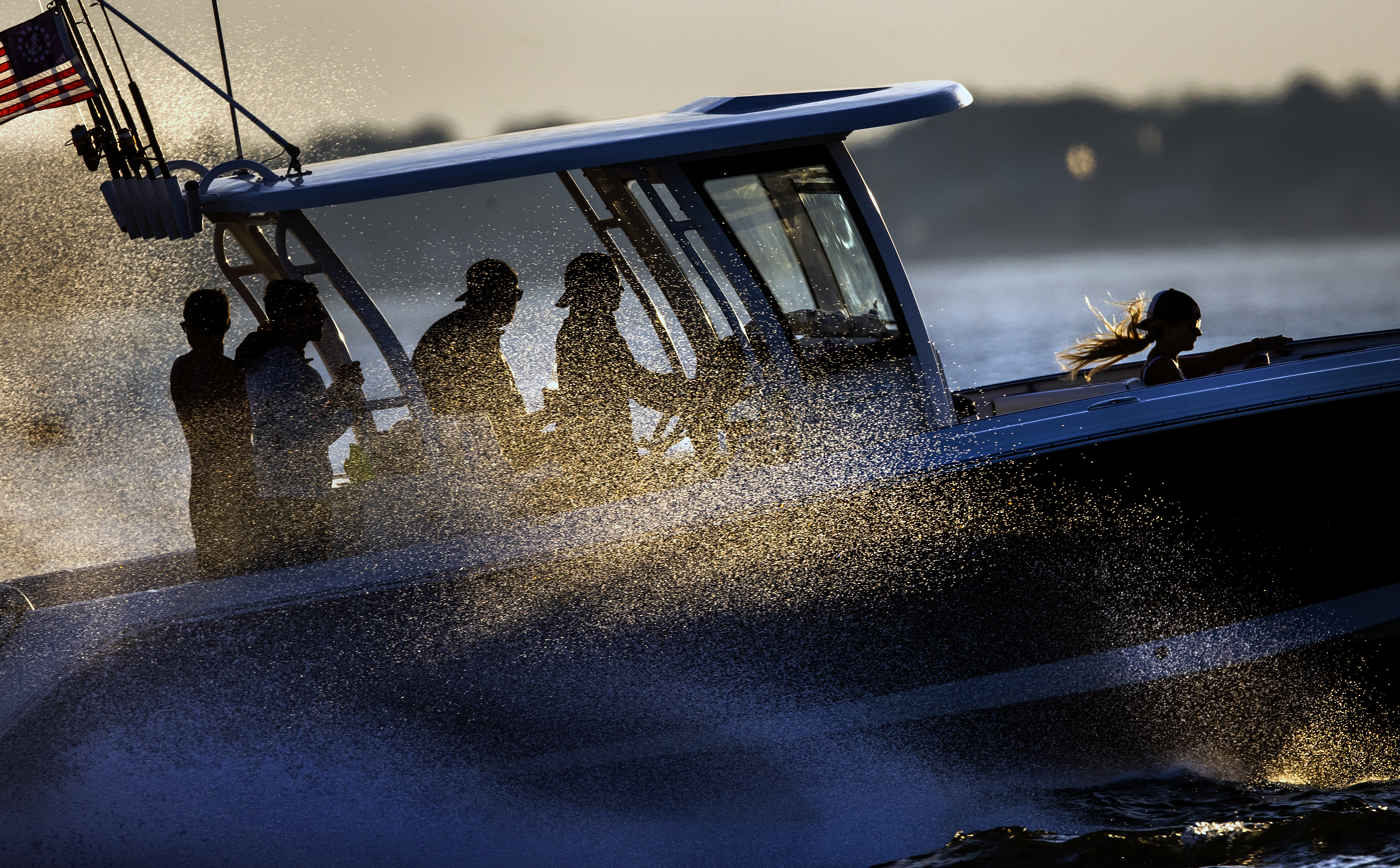 A motorboat sped through the waters off Hull as the sun illuminated the ocean spray.