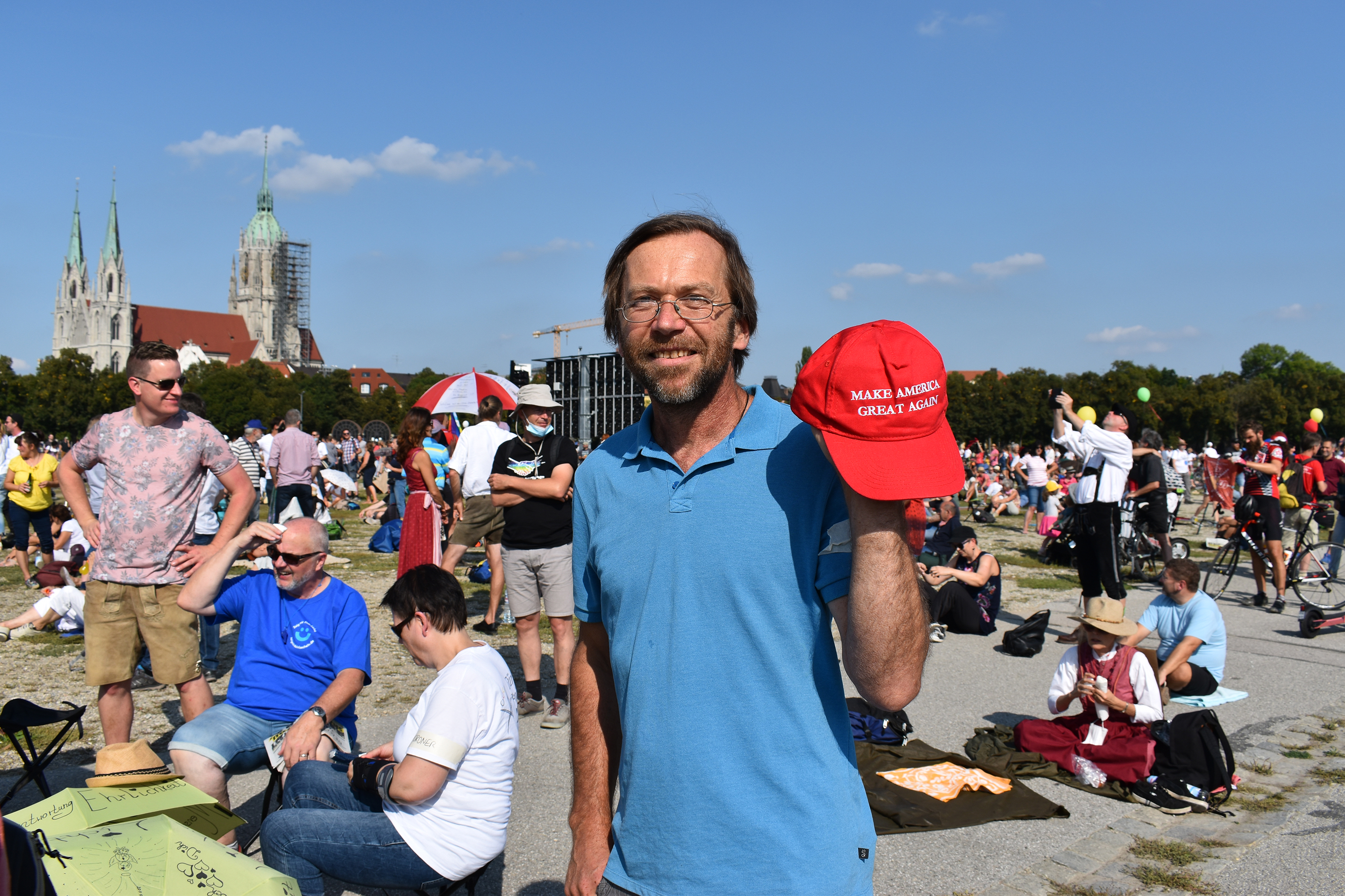 An anti-mask demonstrator in Germany holds a Trump hat.