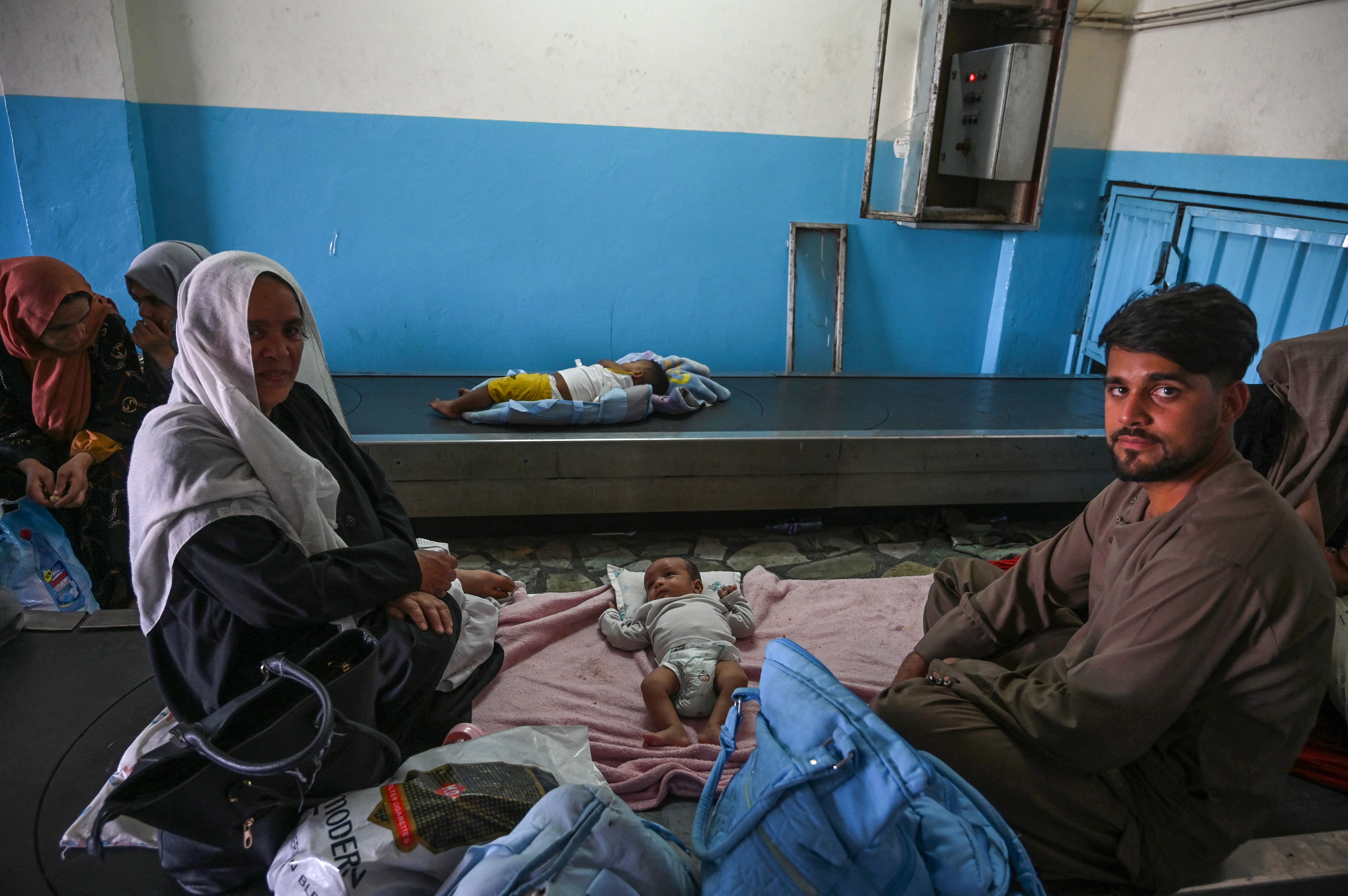 Afghan families waited by the luggage conveyor belt in the Kabul airport.