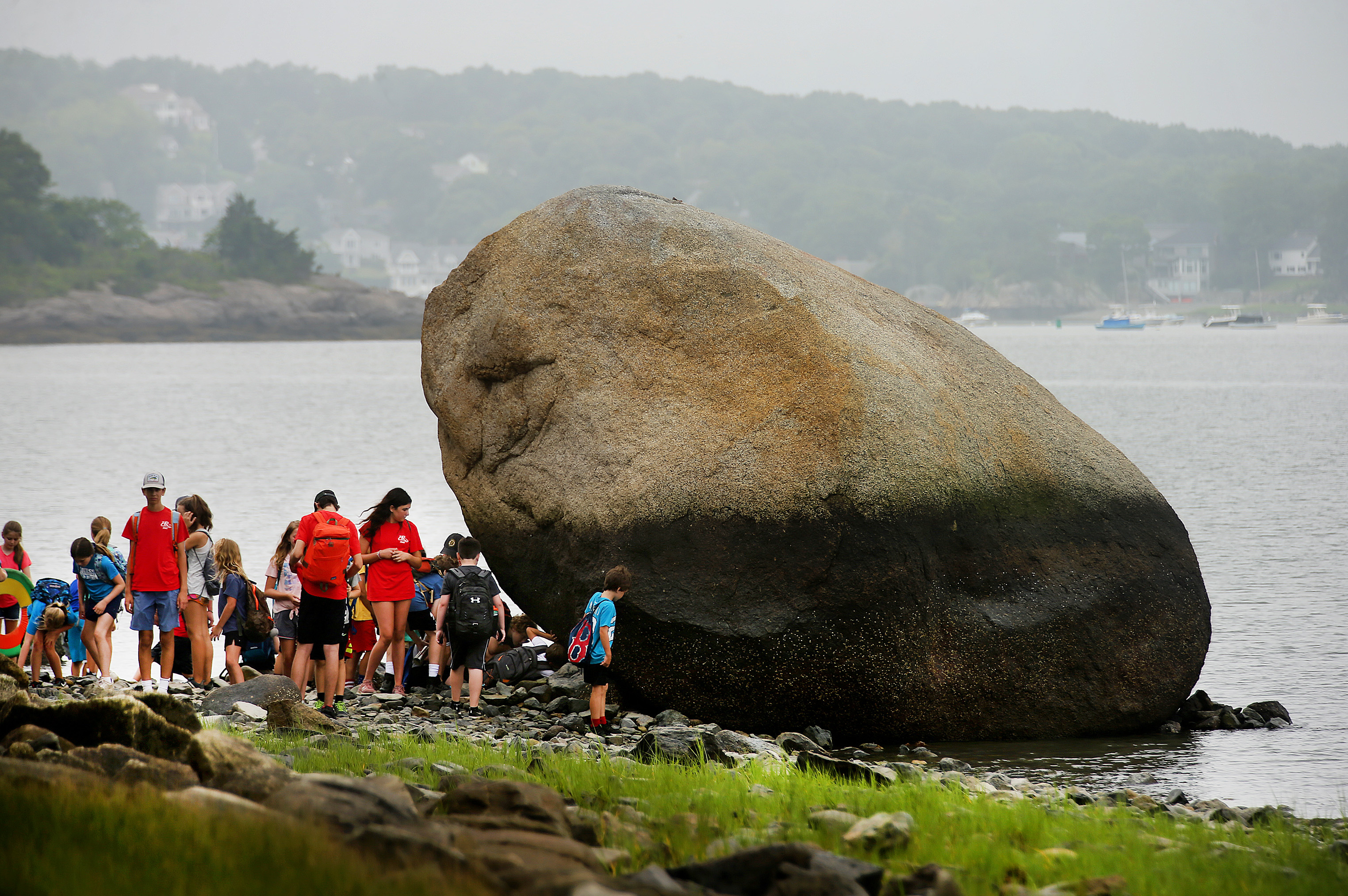 Kids from the Hingham Parks and Recreation Department stop to look at a huge boulder along the shoreline at World's End.