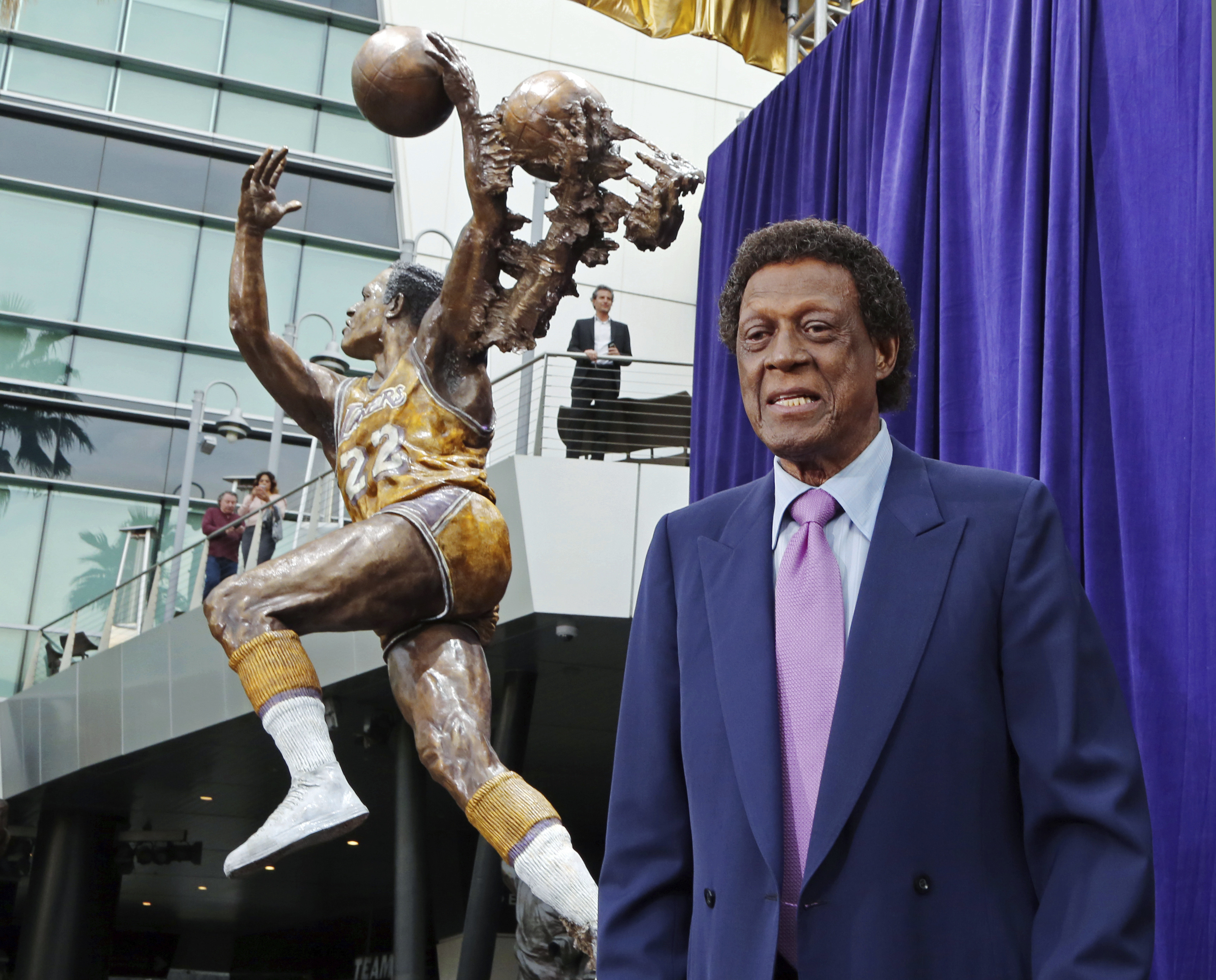 Elgin Baylor stands next to a statue honoring the Minneapolis and Los Angeles Lakers great outside Staples Center in a 2018 ceremony.