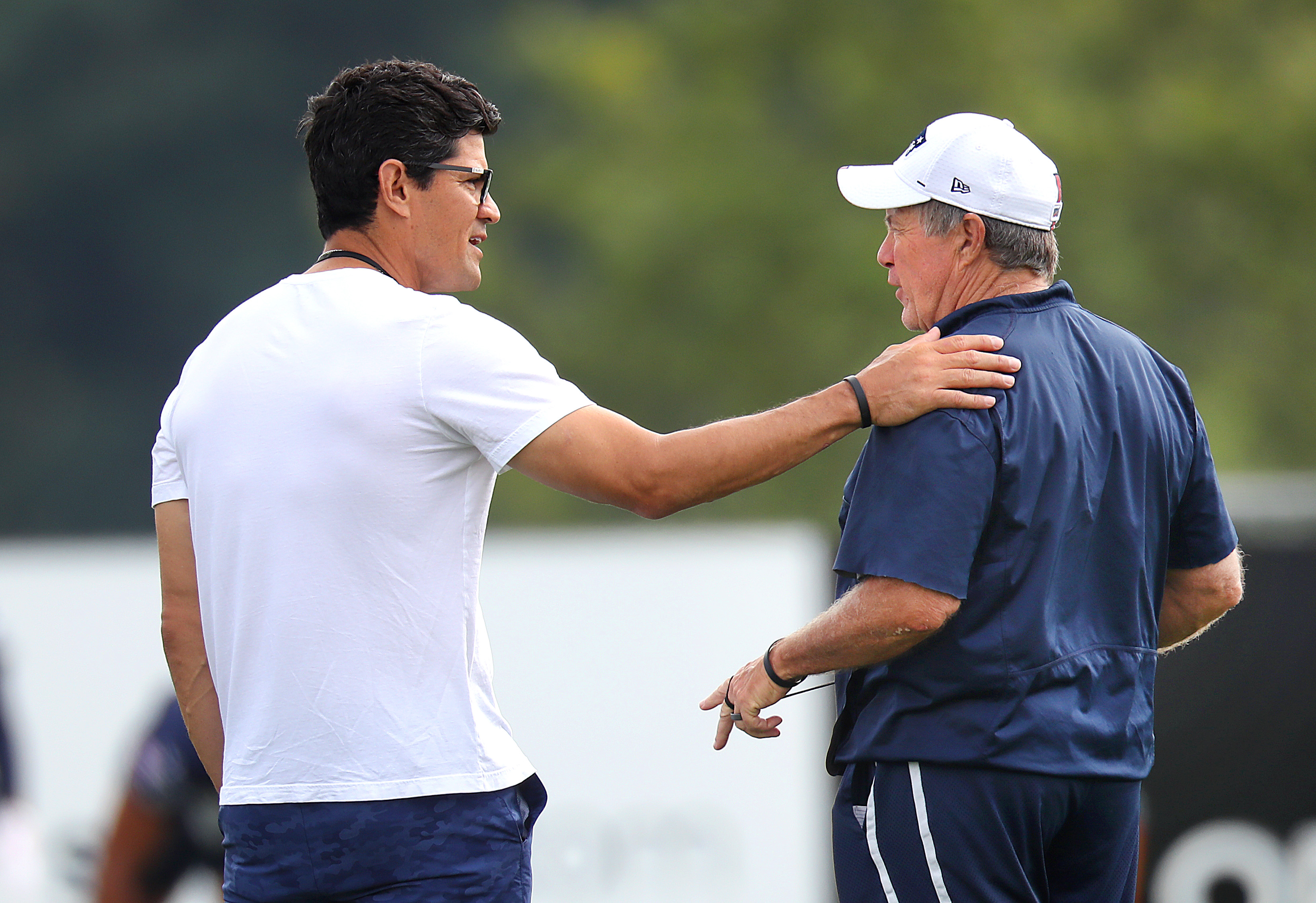 Former Patriots' linebacker Tedy Bruschi chats with Bill Belichick during Thursday's workout.