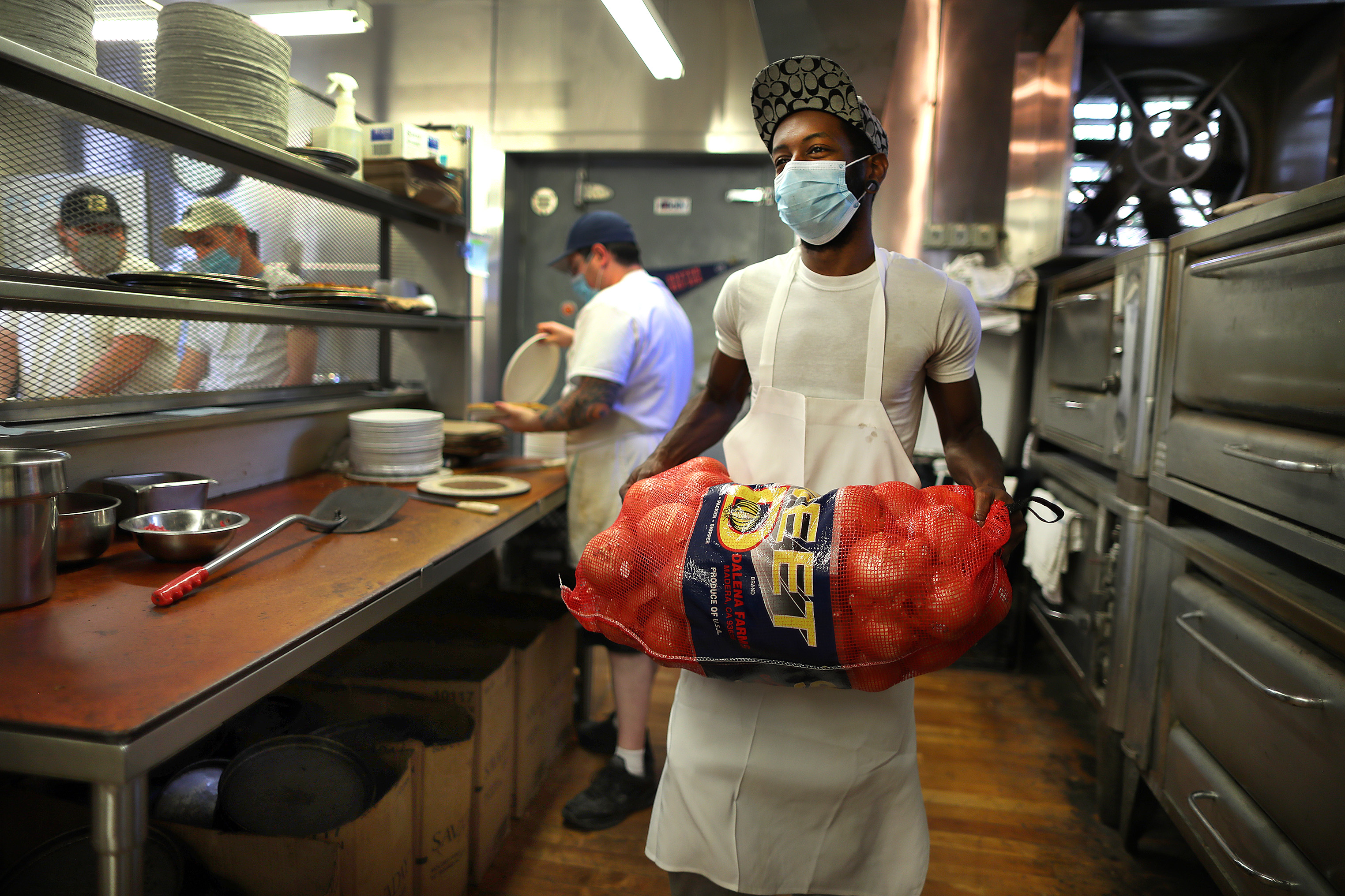 Cook Audley Jean-Baptiste hauls a bag of onions into the kitchen at the Lynwood Cafe.