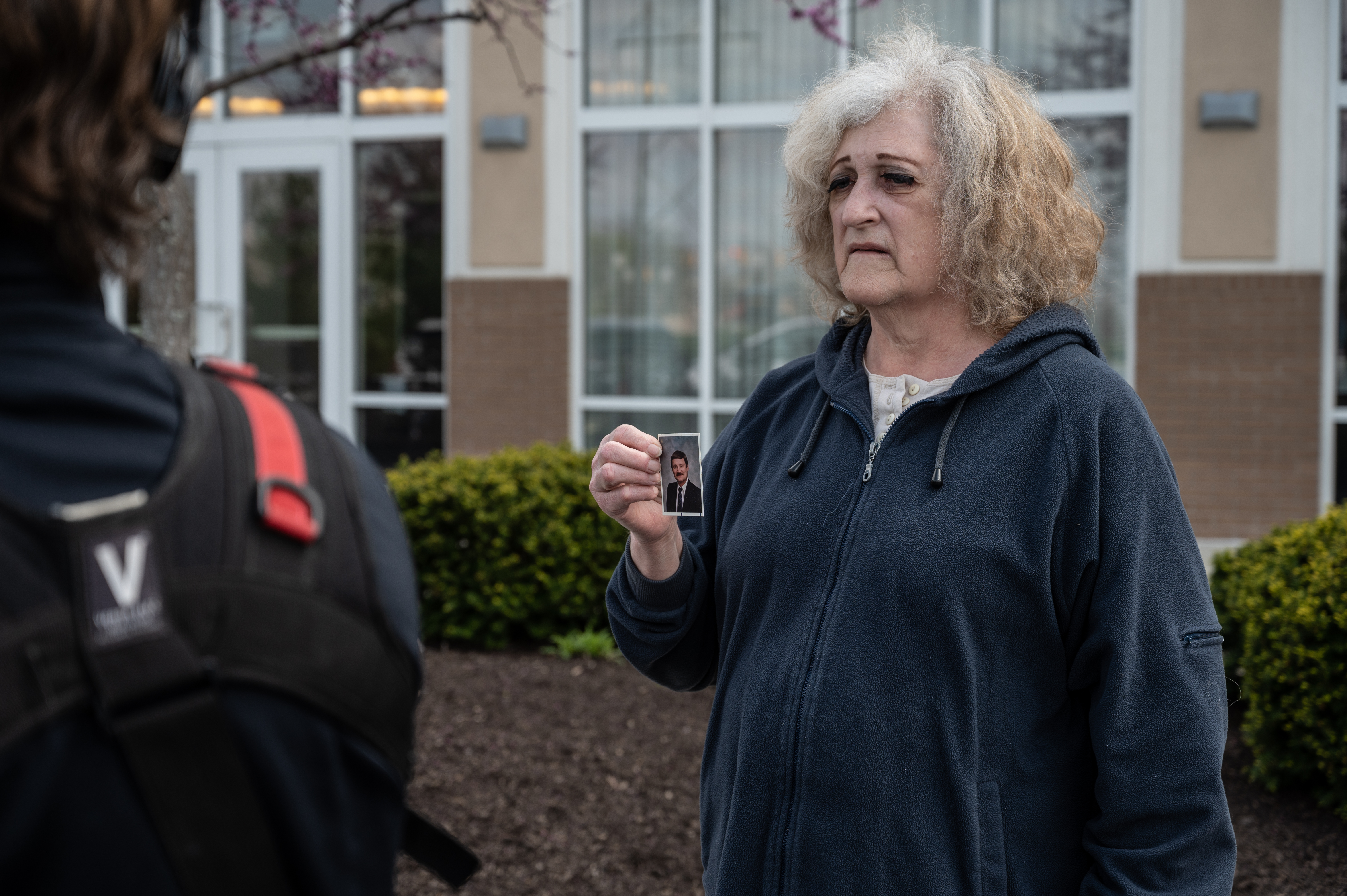 Mary Carol Weisert displays a picture of her husband, John Weisert, near his workplace at a FedEx ground facility on April 16, 2021 in Indianapolis, Indiana.