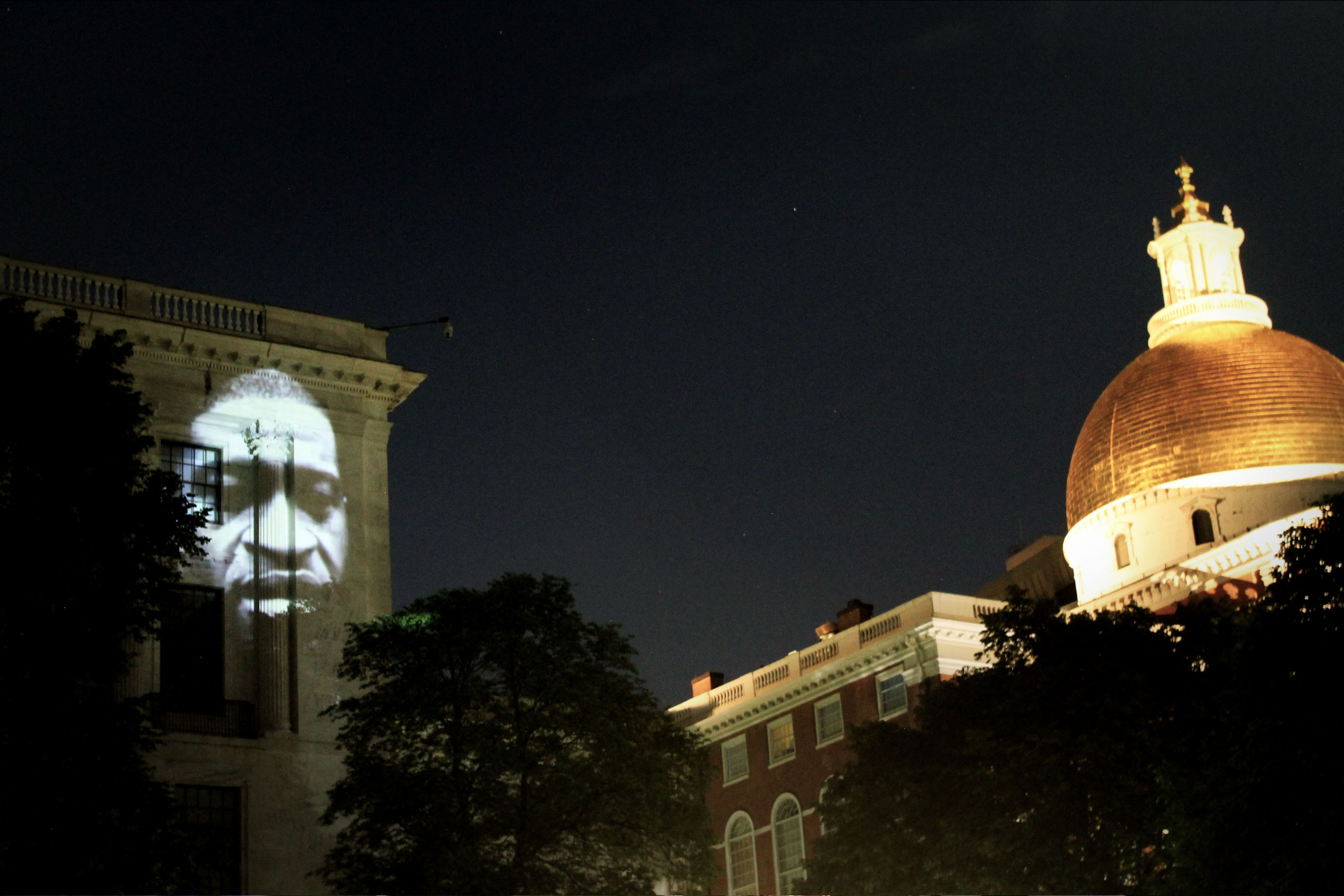 Projection Protests by Sam Okerstrom-Lang and Caleb Hawkins of MASARY Studios, with George Floyd's face lighting up the State House.