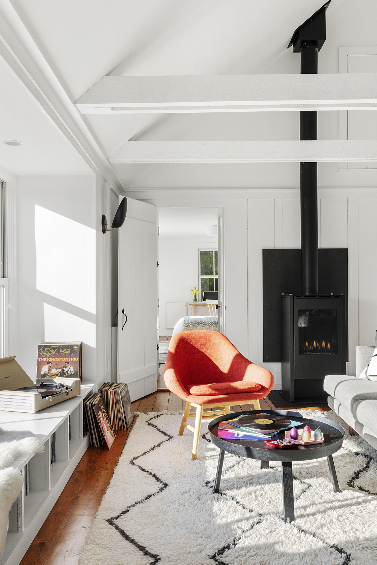 A black steel panel held off the wall with pegs matches the inset steel hearth. “The concept of a heat shield is traditional, but the material and application are cool and modern,” Williams says.