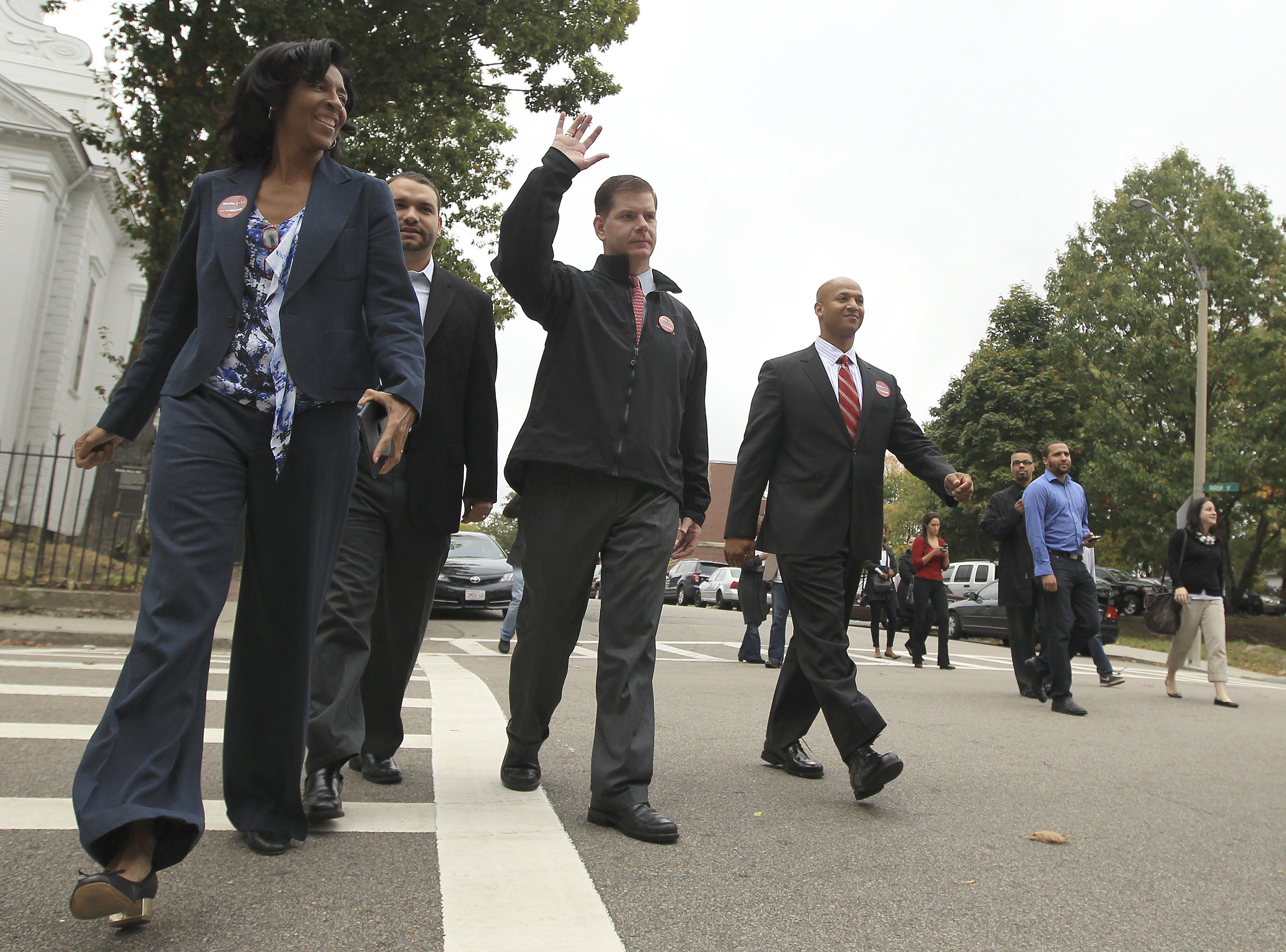 Former Boston mayoral candidates Charlotte Golar Richie (left), Felix Arroyo, and John Barros (right) walked with then-mayoral candidate Martin J. Walsh on their way to a press conference where Golar Richie announced her support for Walsh in 2013.