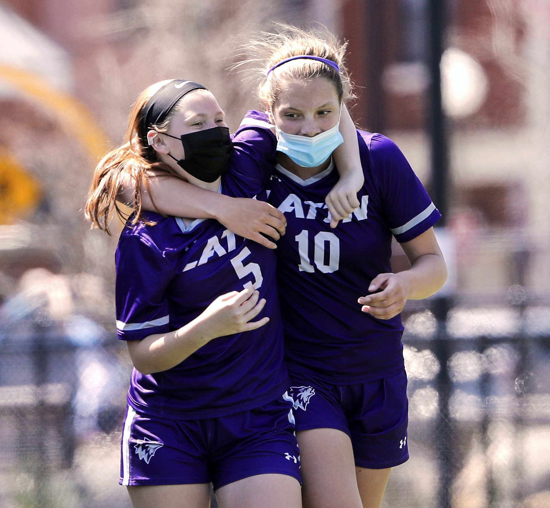 Reagan O’Brien (right) had four goals and two assists in Saturday's win, earning a hug from Boston Latin teammate Lilah Conroy.