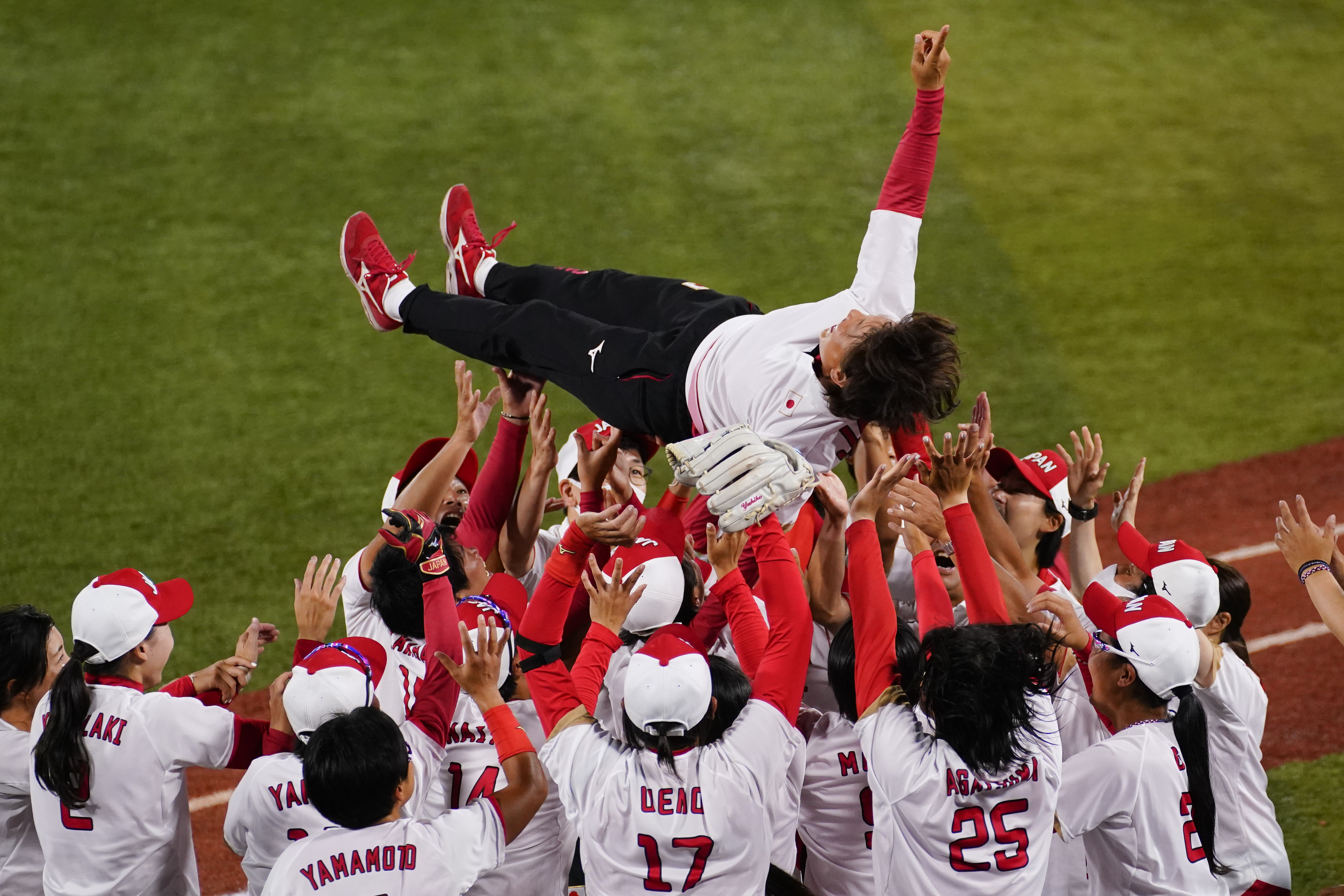 Members of Team Japan celebrates with head coach Reika Utsugi after their win over the United States.