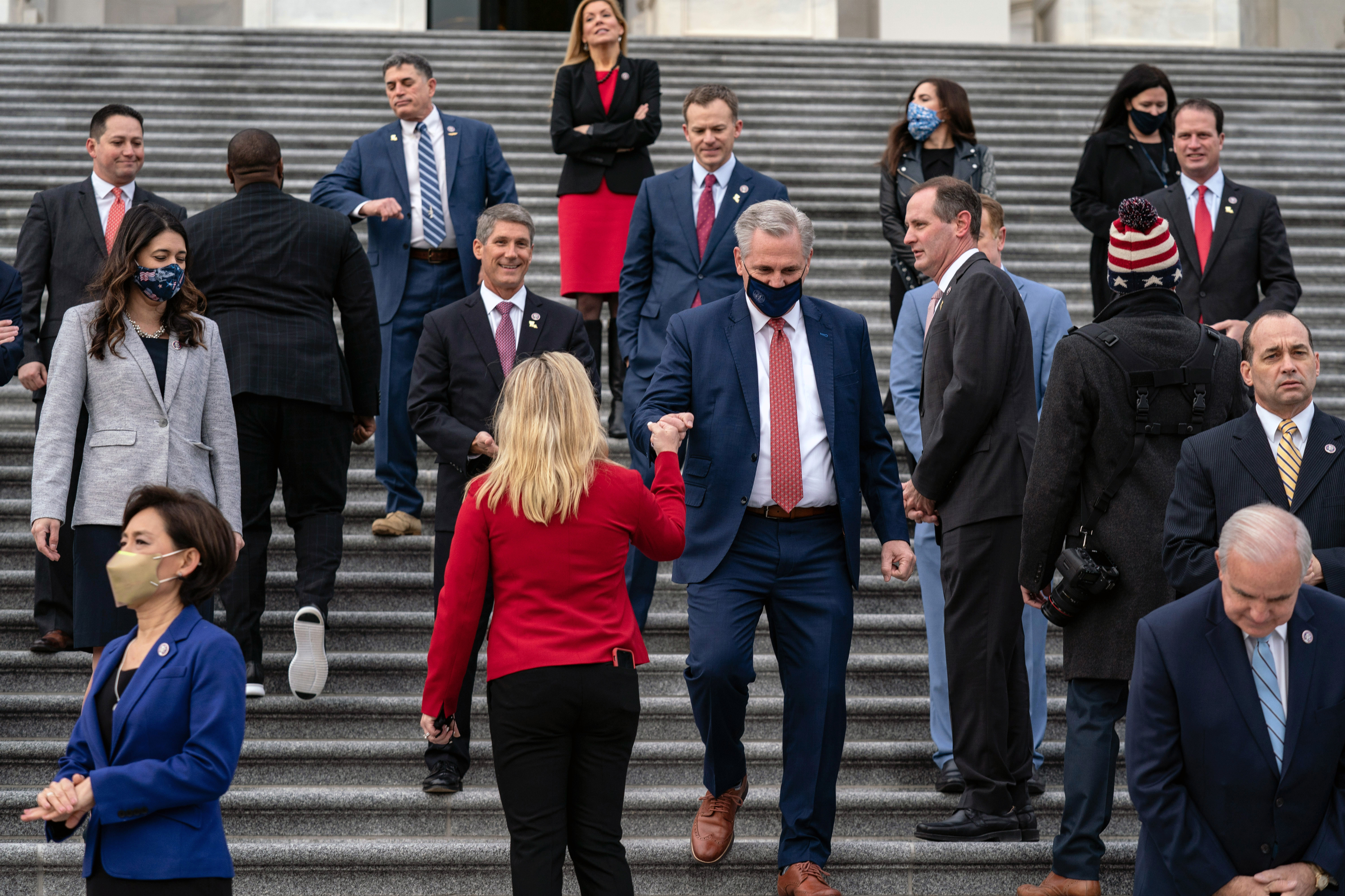 Kevin McCarthy, the House minority leader, bumps fists with Representative Marjorie Taylor Greene as he arrives to pose for a group photo with freshman Republican members of the House of Representatives at the Capitol on Jan. 4.