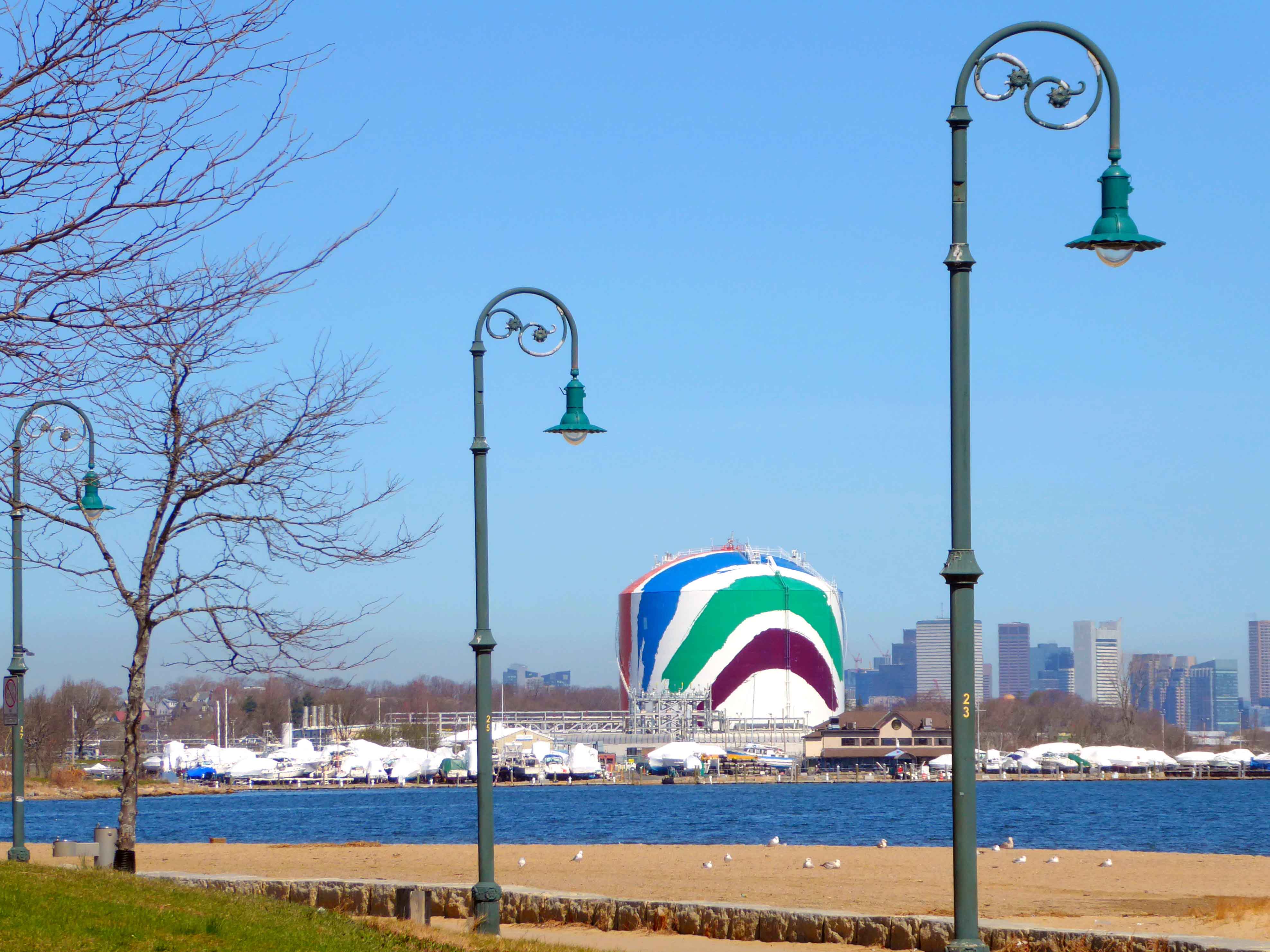 The sliver of sand at Tenean Beach has a front-row seat on Corita Kent's rainbow-splashed Dorchester gas tank.