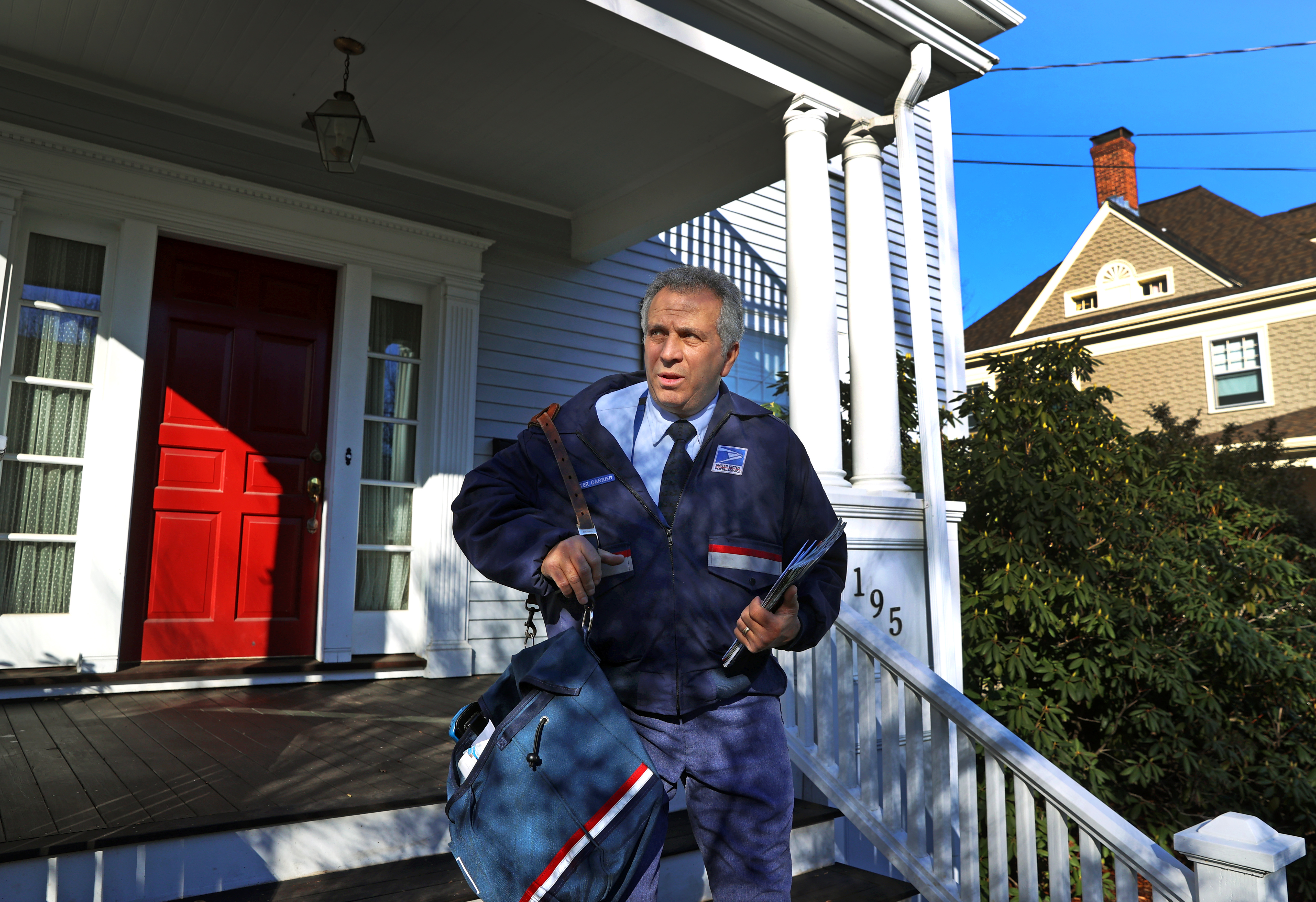 During holiday rush, a cheerfully old-school letter carrier picks