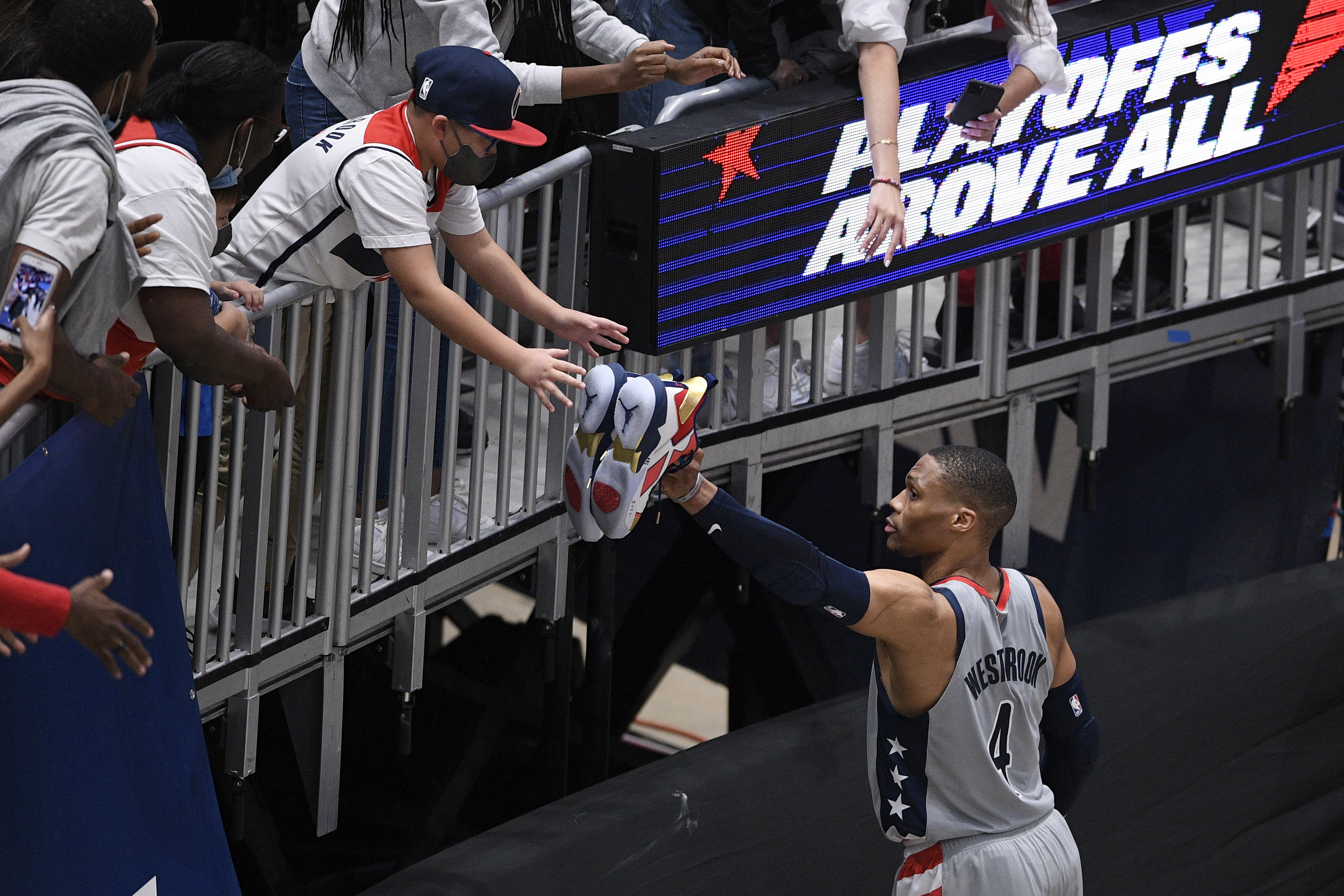 Washington's Russell Westbrook gives his shoes to a fan after Monday's Game 4 win over Philadelphia.
