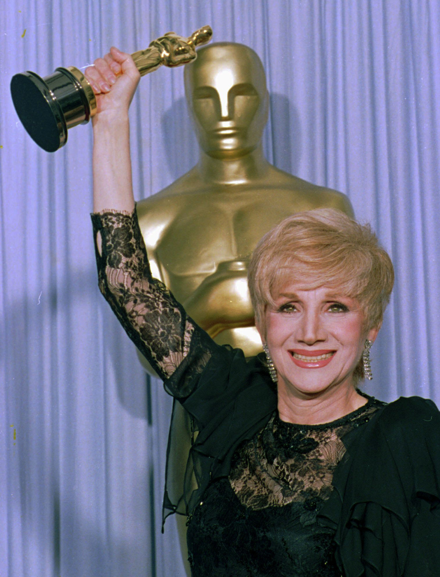 Olympia Dukakis held up her Oscar after winning the award for best supporting actress for her role in "Moonstrck."