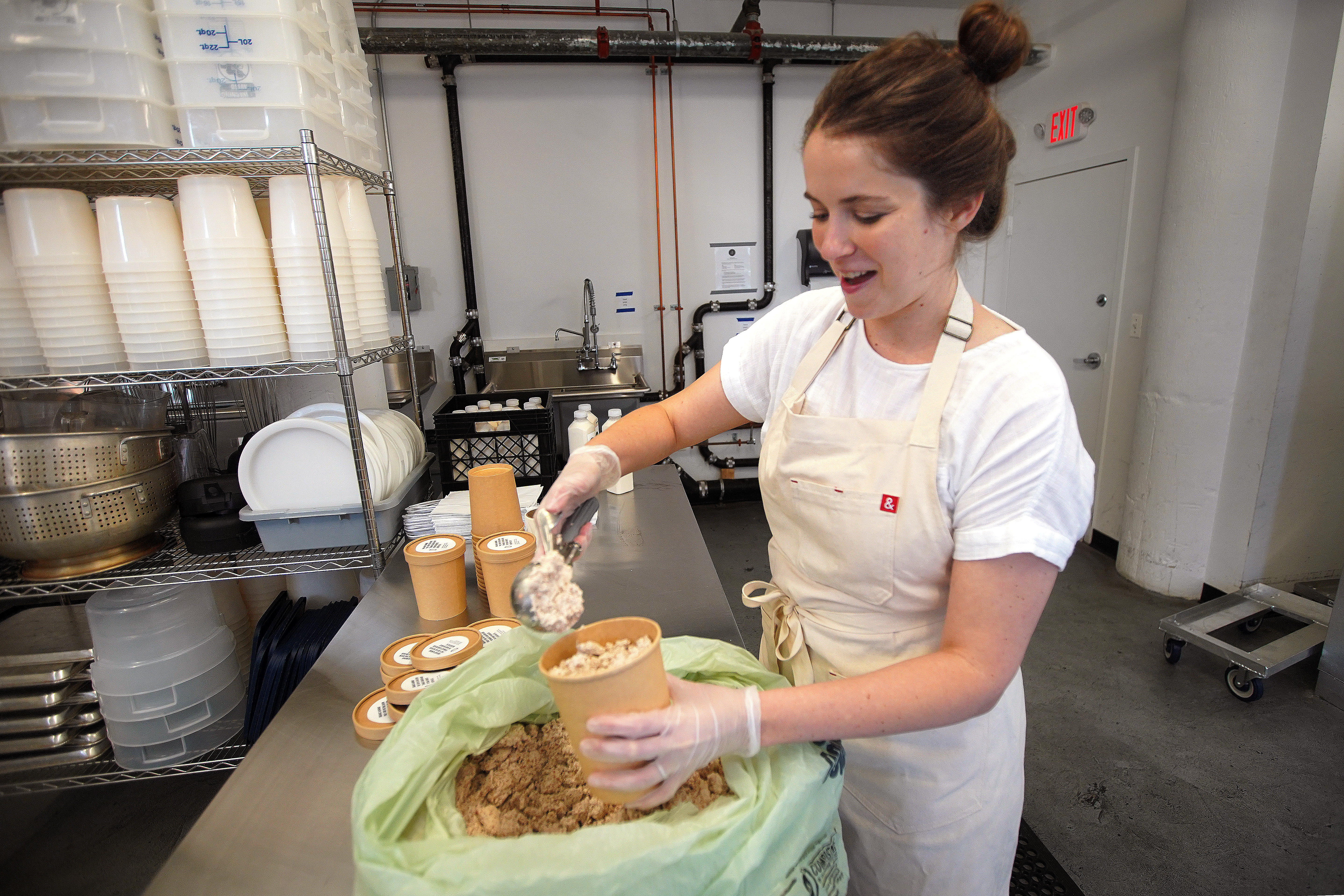 Laurel McConville, founder and CEO of Nectar and Green, packs fresh-pressed almond milk and almond pulp into surprise bags to sell on the app Too Good To Go.