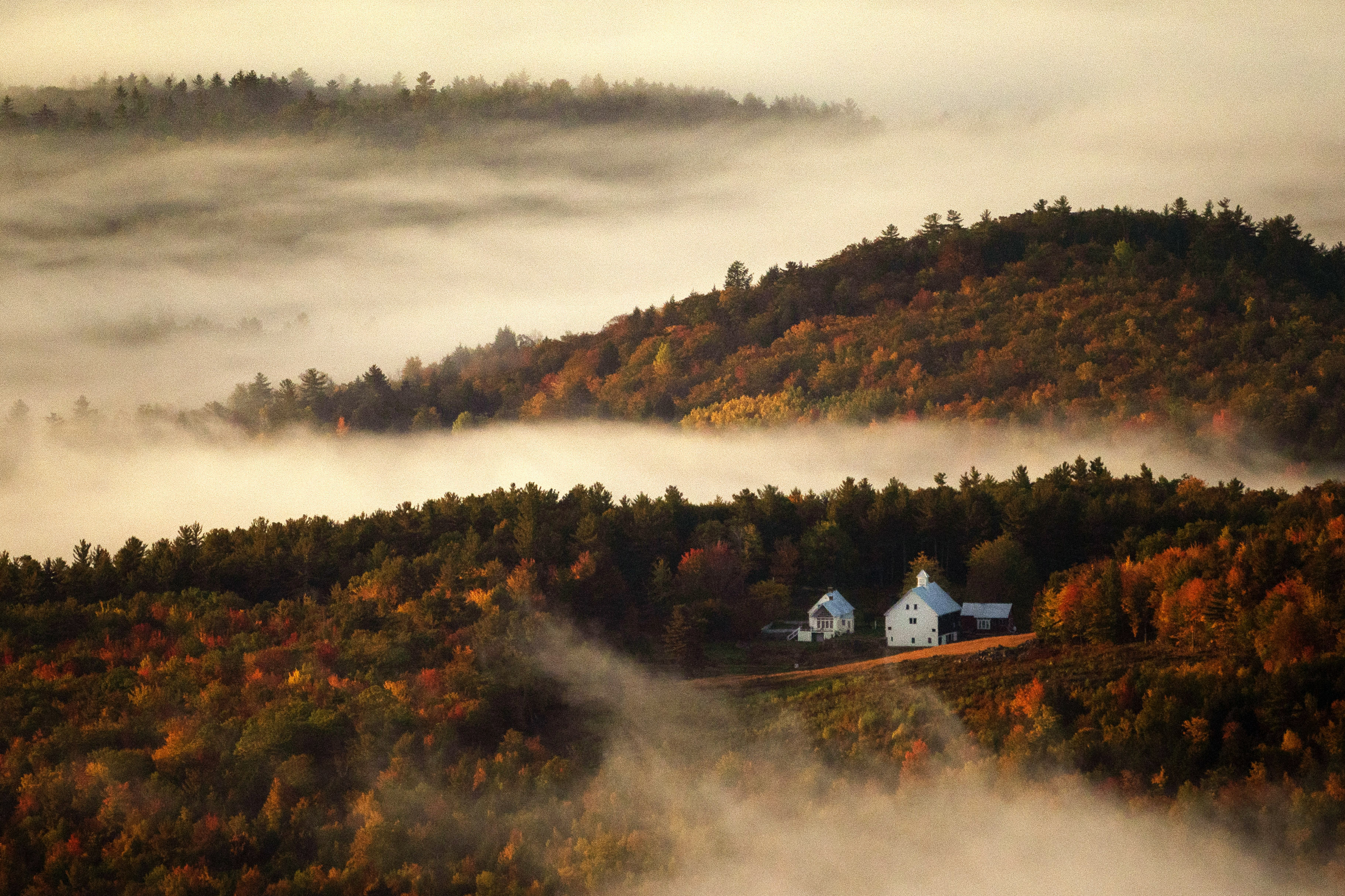 Valley fog wafts through the autumn-colored hills near the Picket Hill Farm last week in Denmark, Maine.