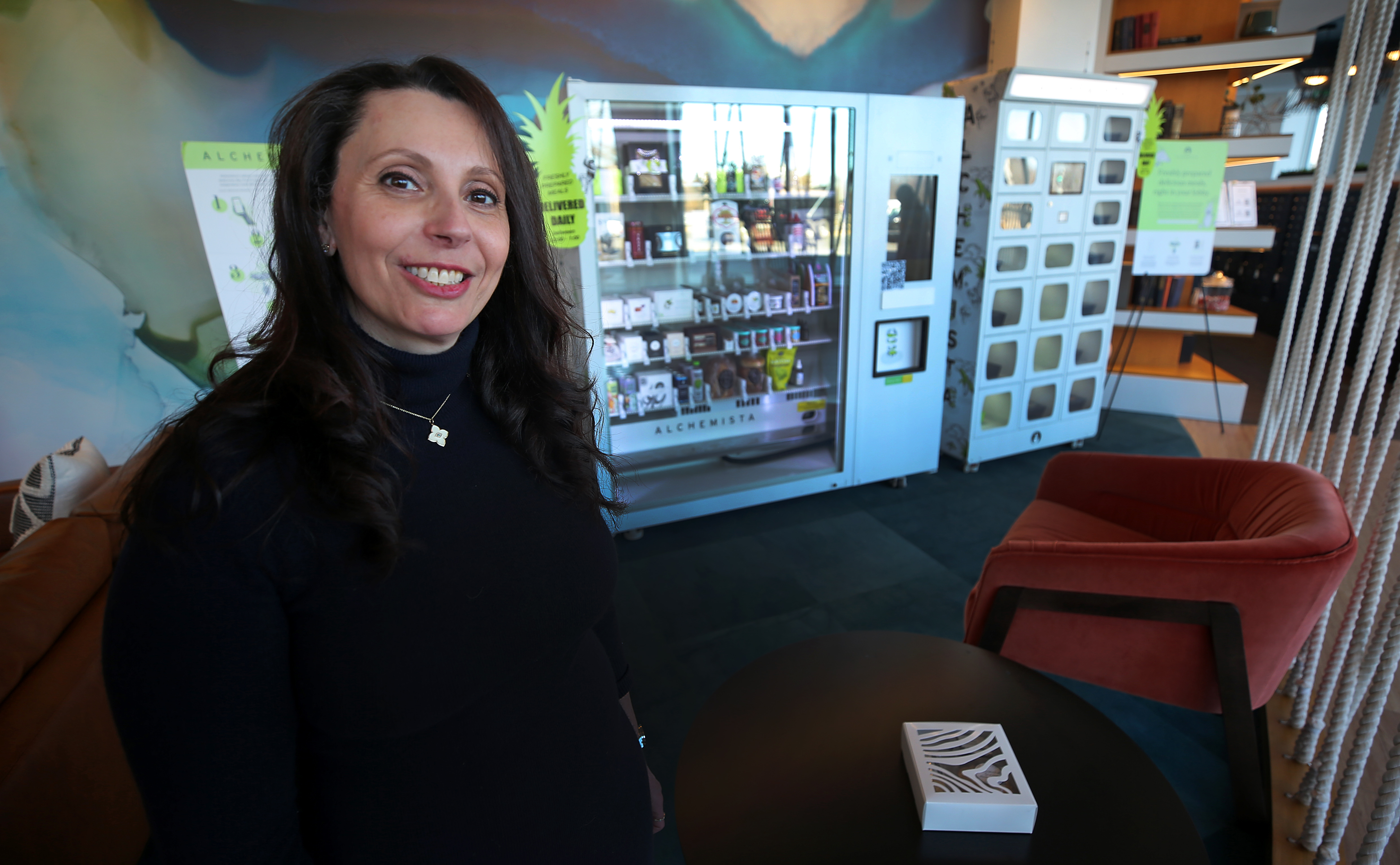 Christine Marcus, founder and chief executive of Alchemista, stands in front of her food lockers in the lobby of Radius Apartments in Brighton.