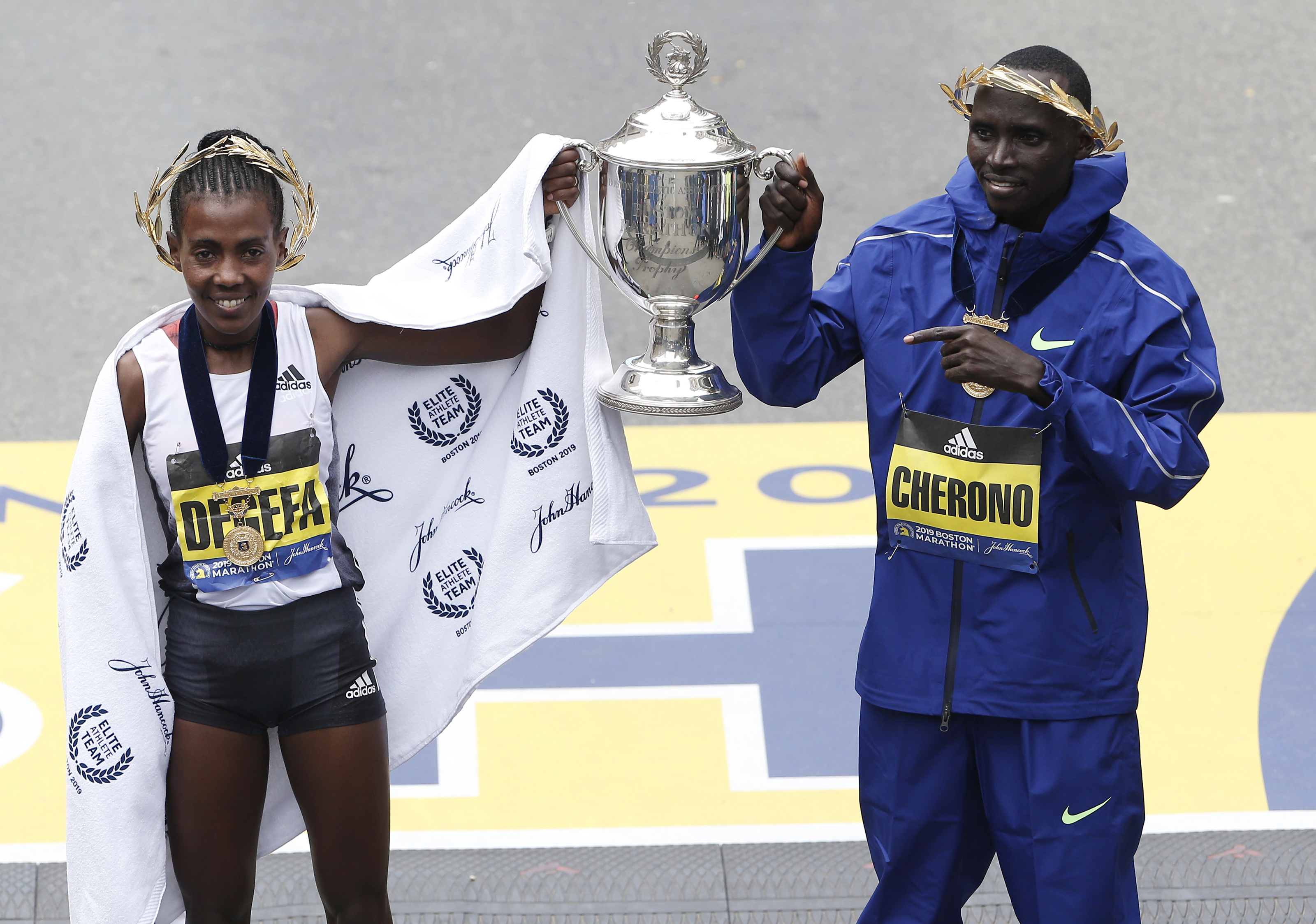 Winners Worknesh Degefa and Lawrence Cherono hold the trophy at the finish line in April 2019.