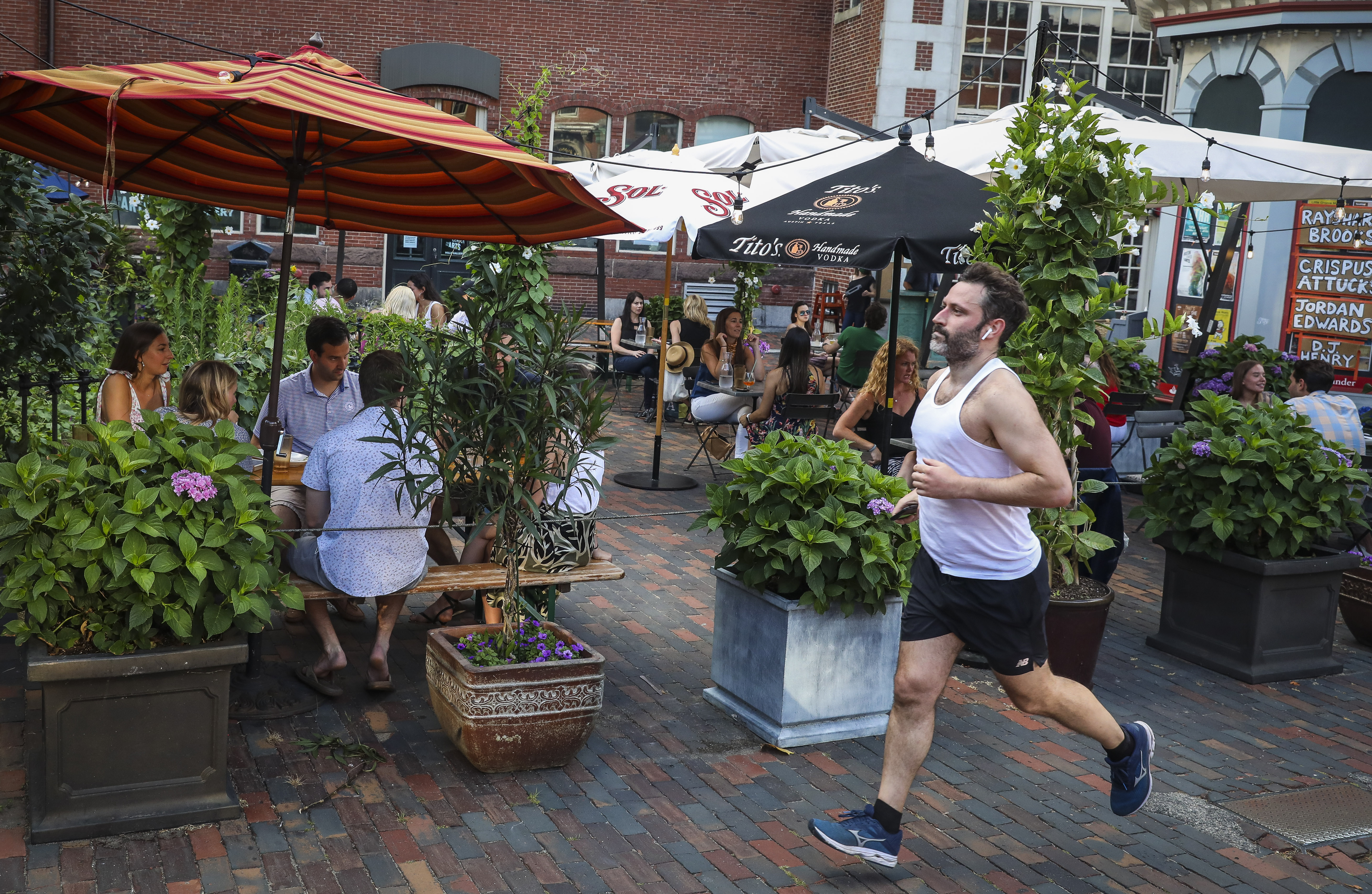 A man jogs past the patio at the Beehive as people enjoy their dinner in the South End.