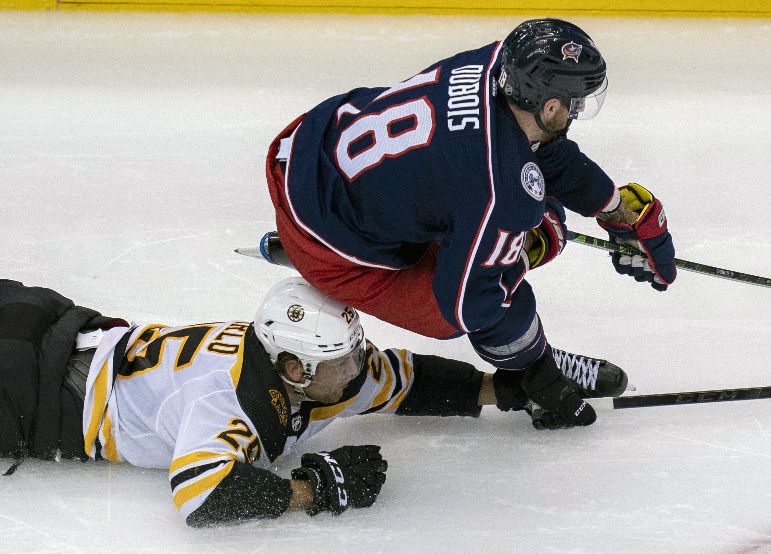 Bruins defenseman Brandon Carlo (25) picks up a tripping penalty as he takes down Columbus Blue Jackets center Pierre-Luc Dubois (18) during the second period Thursday night. in Toronto.