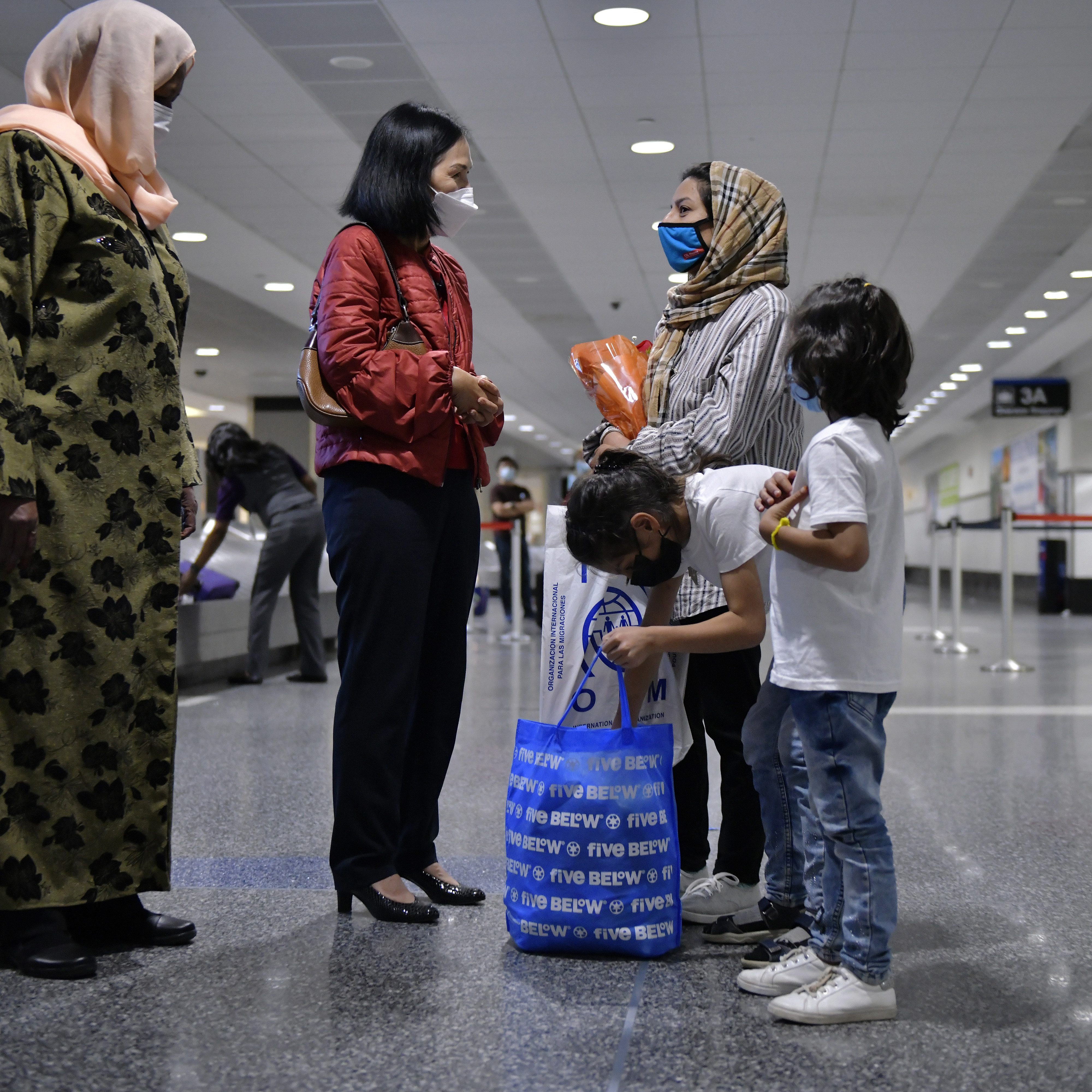 Members of a family of five Afghan evacuees were greeted by Miriam Gas (above left), founder of the Refugee and Immigrant Assistance Center in Boston, and Mary Truong, director of the state office of refugees and immigrants, at Logan Airport.