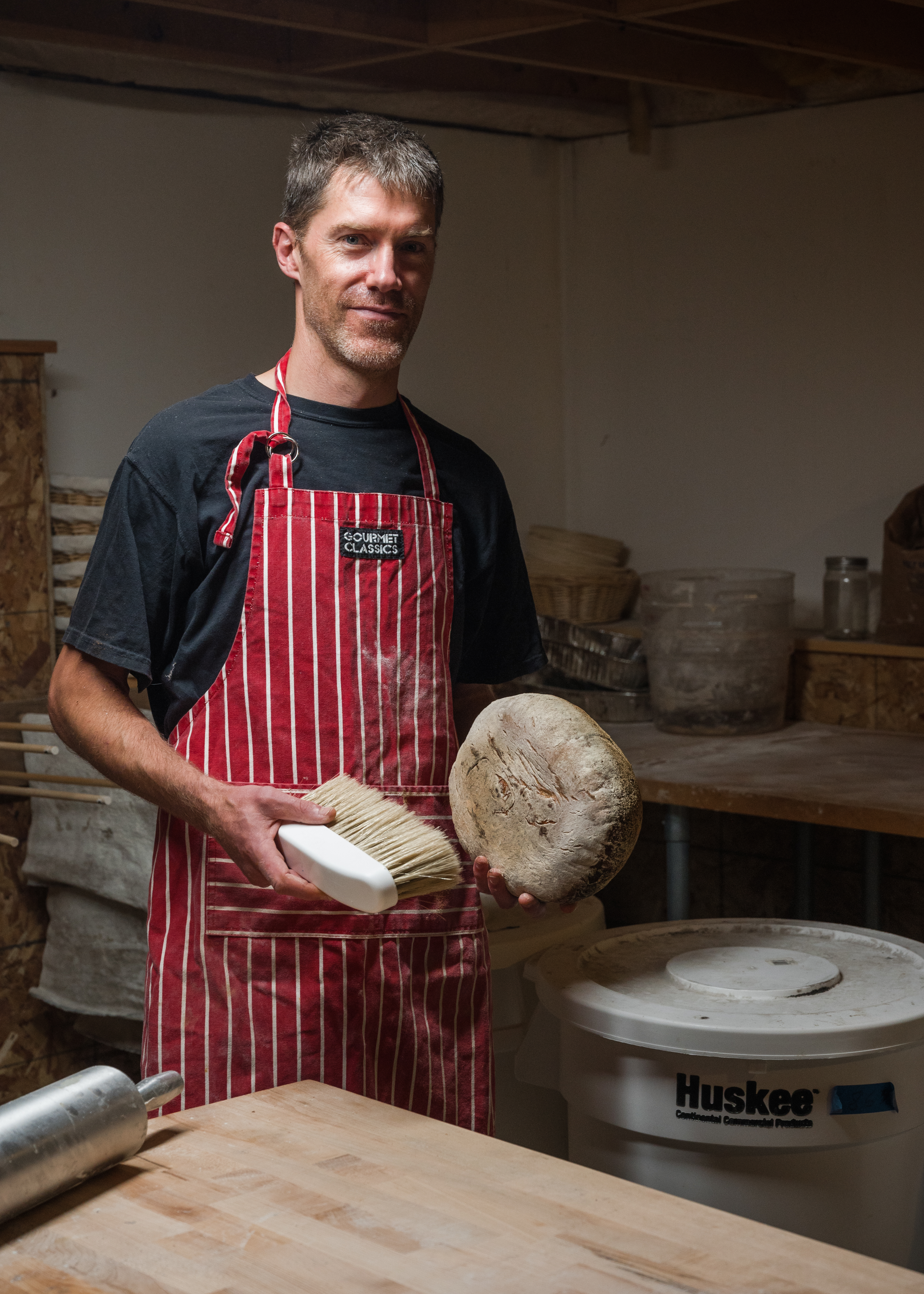 Reeve Wood, 41, a former staff attorney for the Maine Farmland Trust and now baker and founder of Counterpoint Bread, stands for a portrait in his home bakery in Bowdoinham, Maine on Thursday, Aug. 5, 2021.
