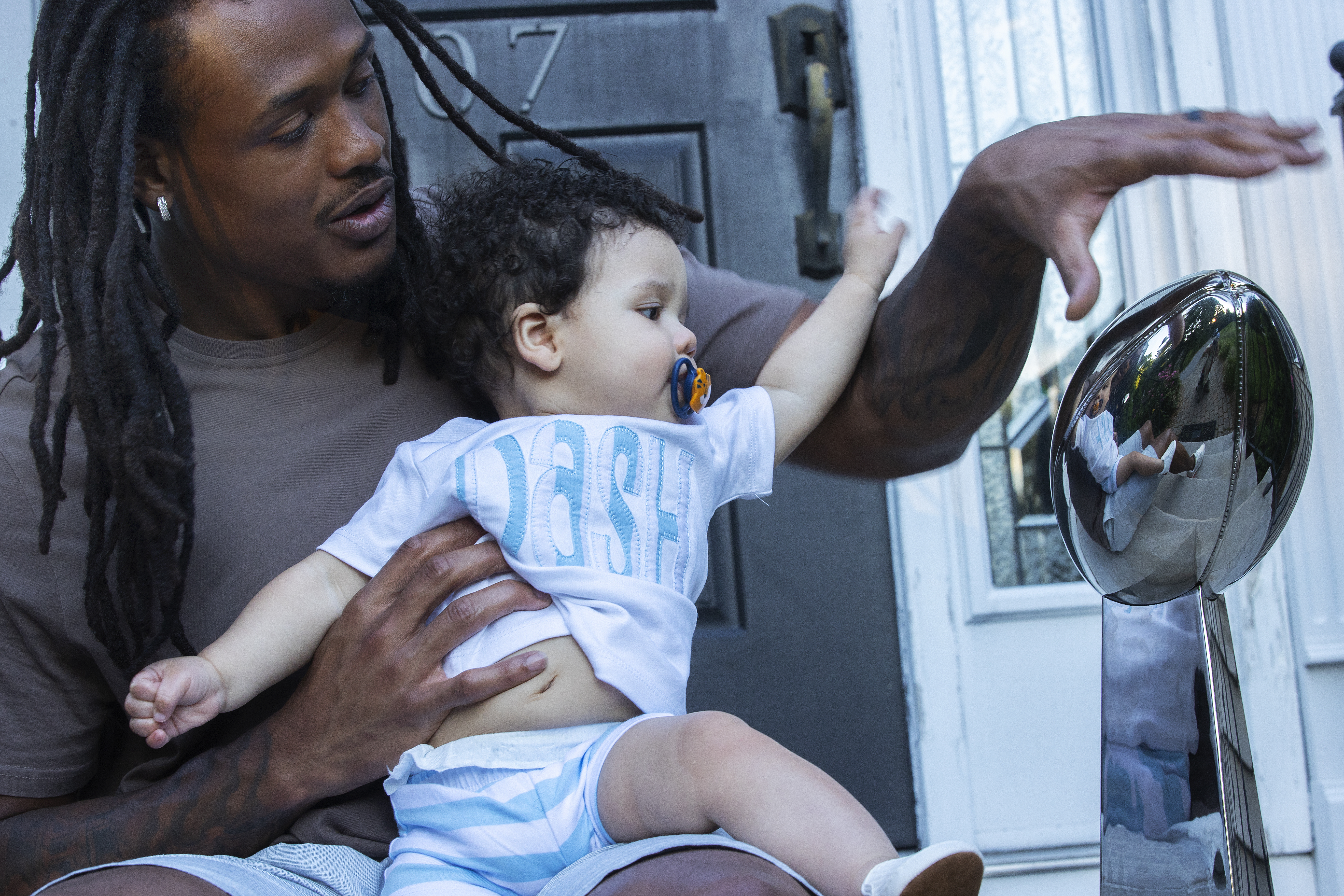 Hightower and son Grayson check out one of the linebacker's replica Lombardi Trophies for winning the Super Bowl.