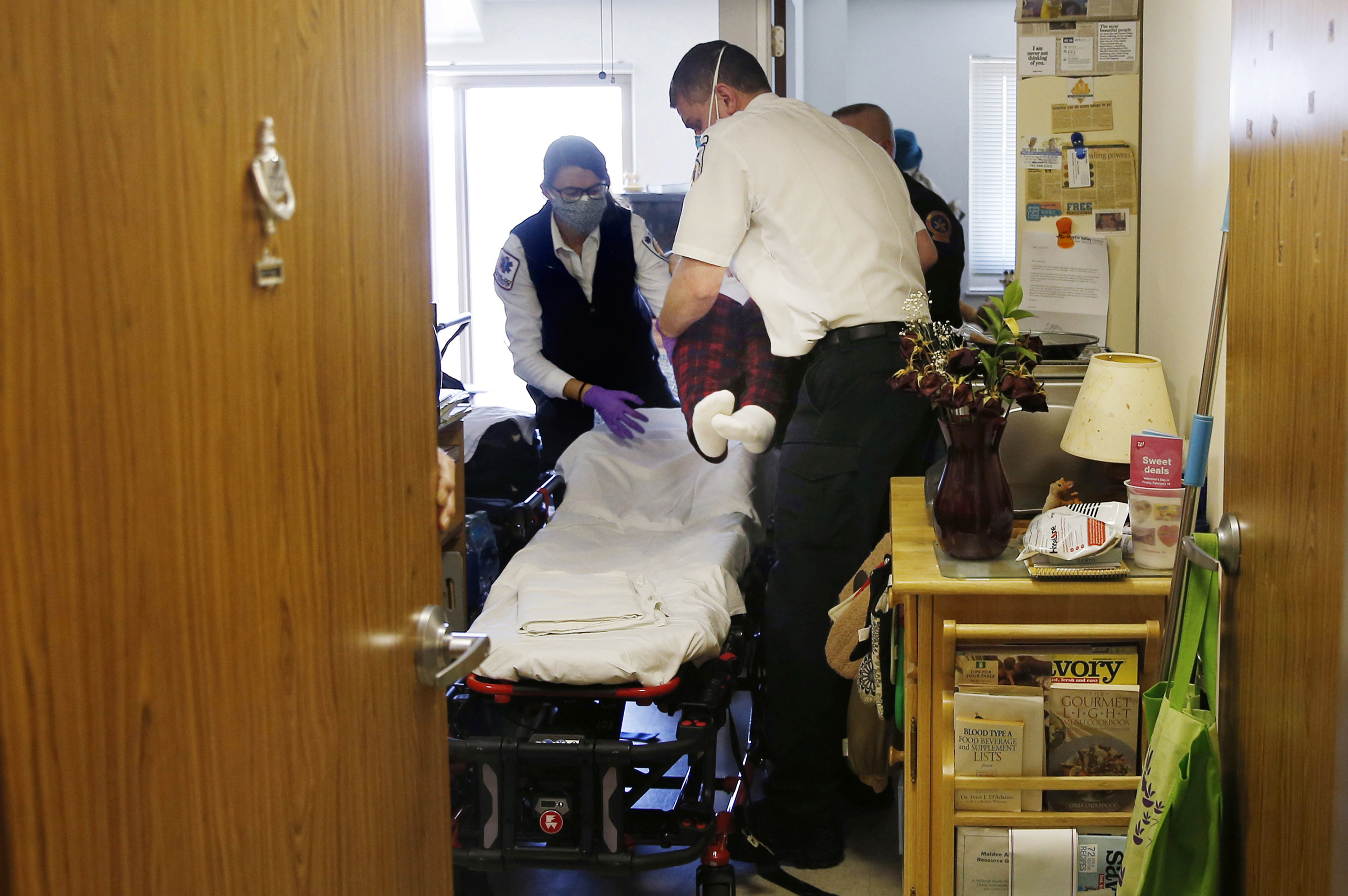 Monday, 9:23 a.m. EMT Emily Moran of Melrose and paramedic Ricky Cormio of Medford lifted an elderly patient who had a fever, a possible sign of COVID-19, onto a stretcher for transport to Mass General Hospital, their second call of the day.