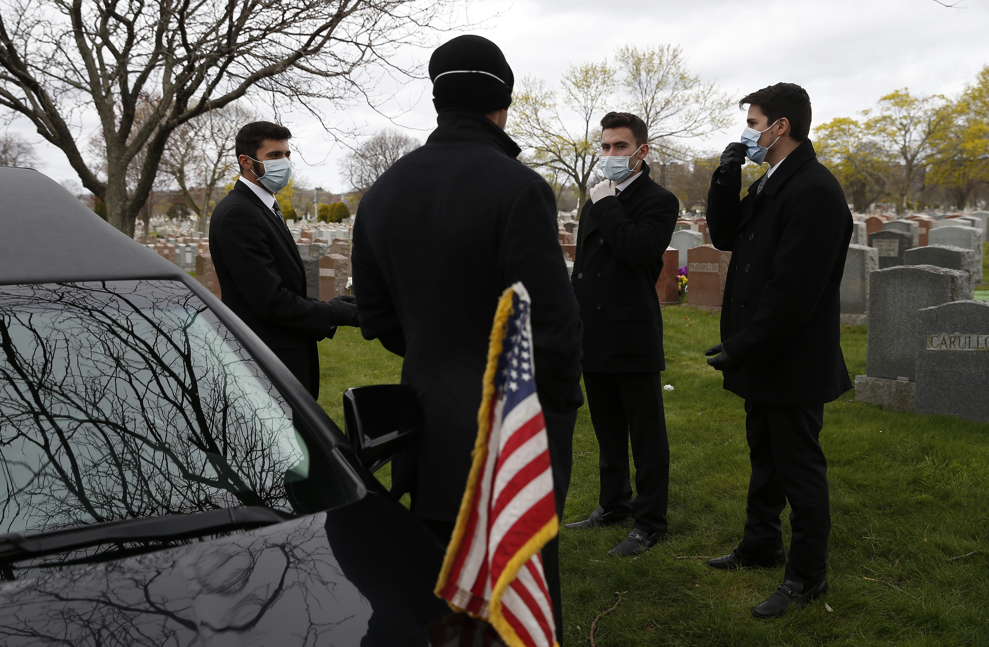 Matt Tauro, Michaelangelo Gerardi, John Lockhead, and Nick Turco waited for the family to arrive at a graveside funeral held for a man who died of COVID-19.